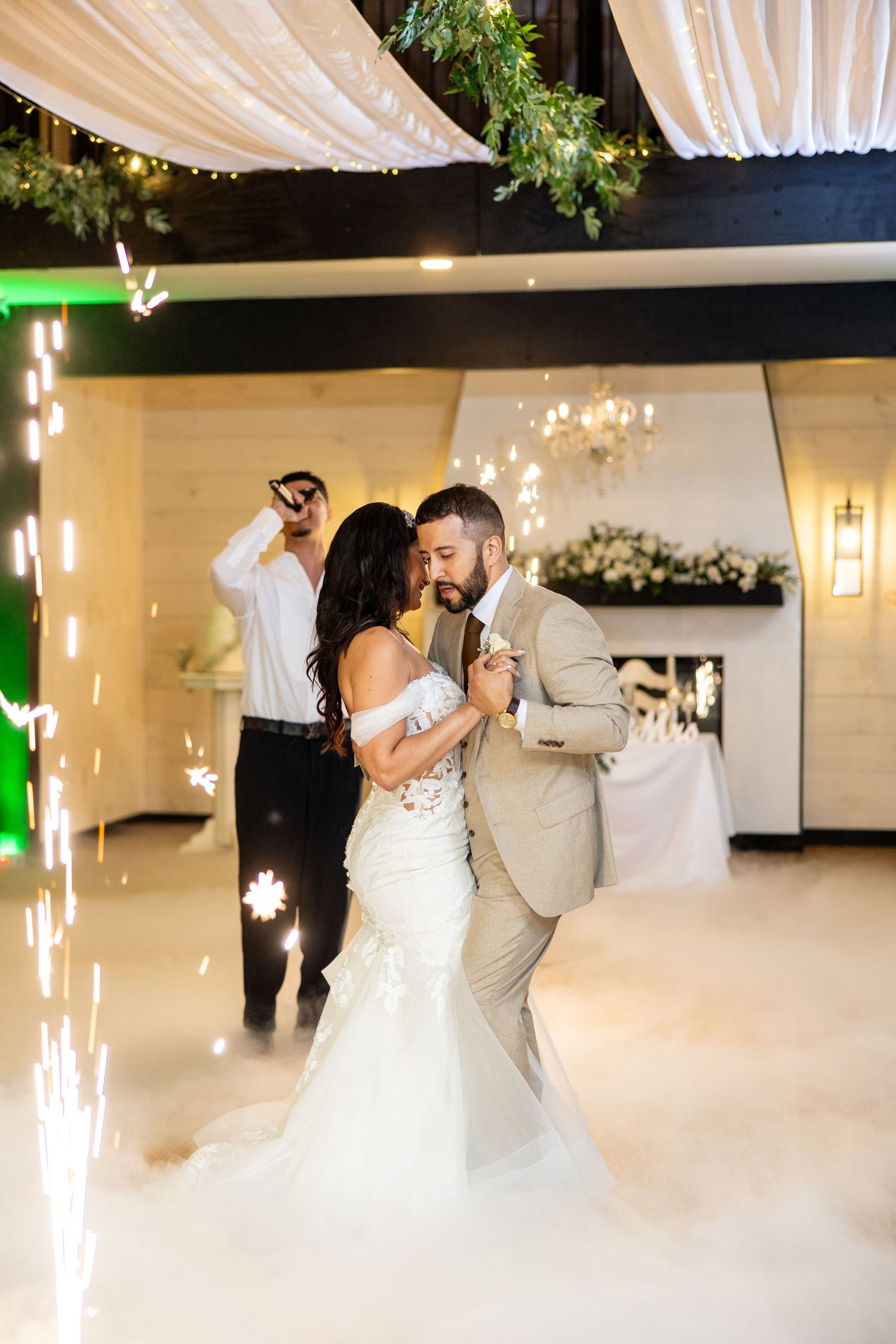 Romantic first dance at a wedding with white draping and dramatic fog effect on the dance floor.