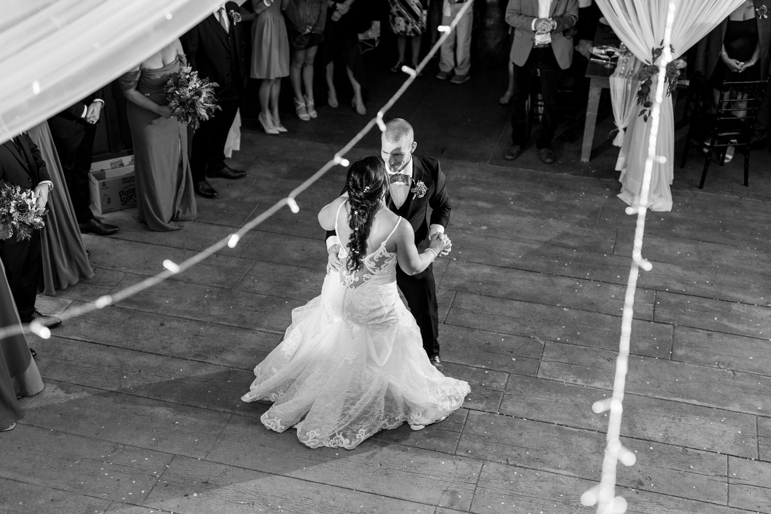 A couple spins during their romantic dance on a rustic wooden dance floor.