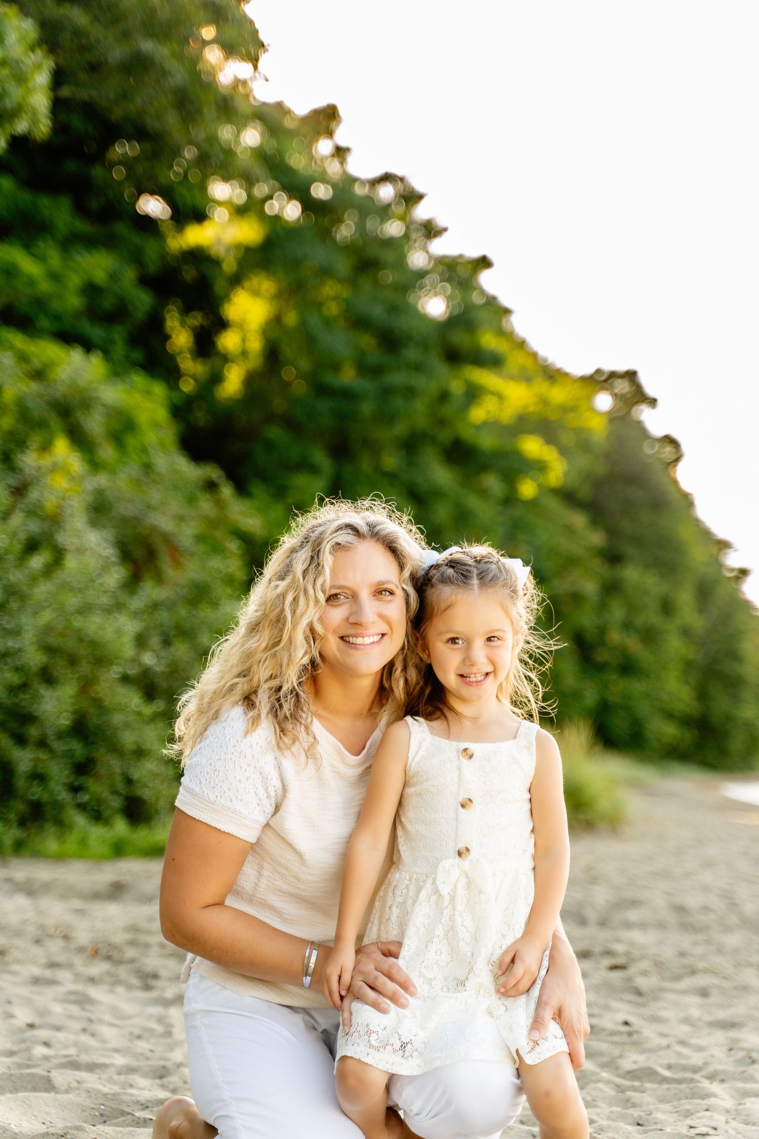 Sun-drenched beach portrait with natural greenery backdrop.