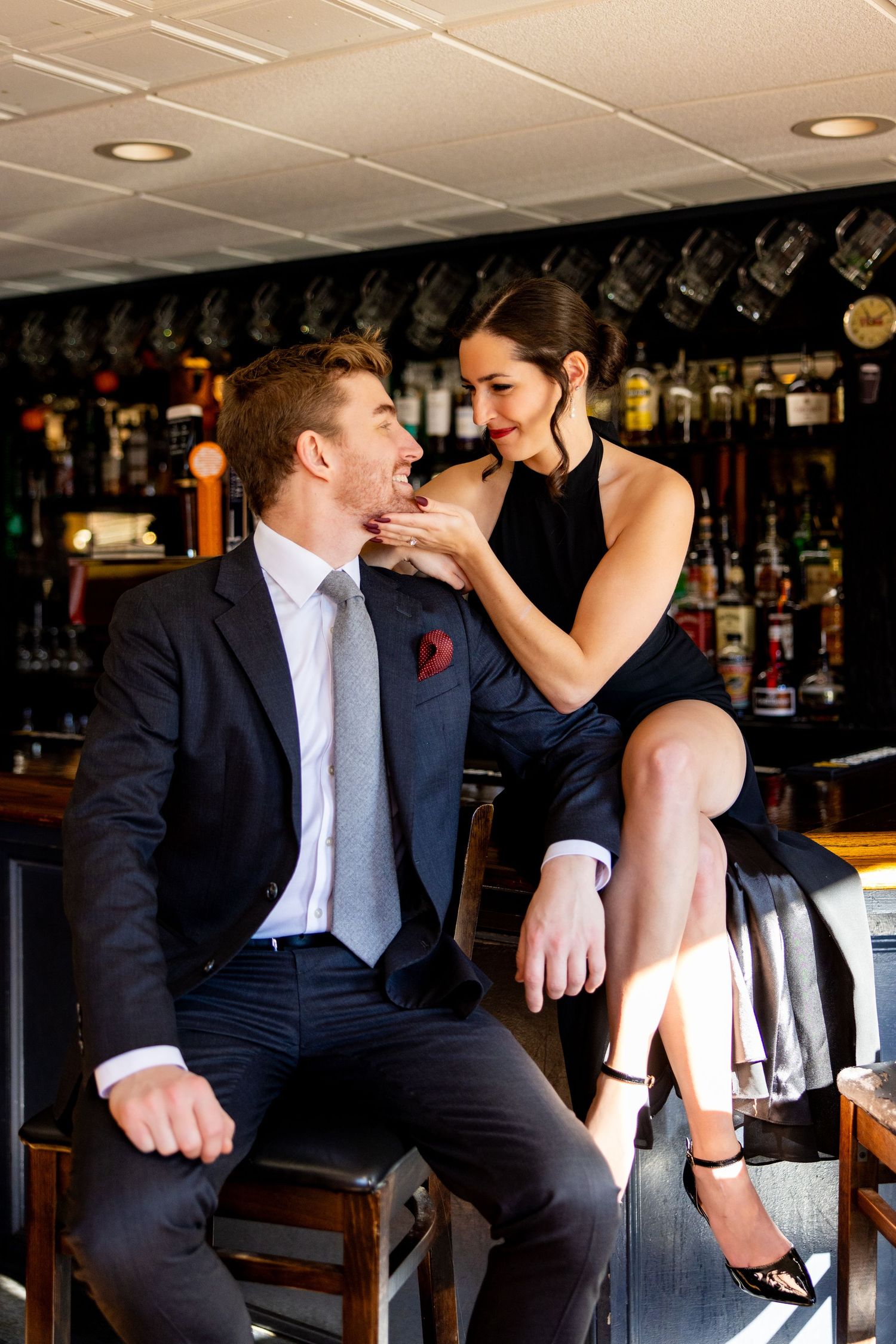Romantic couple in formal attire sharing intimate moment at bar counter.
