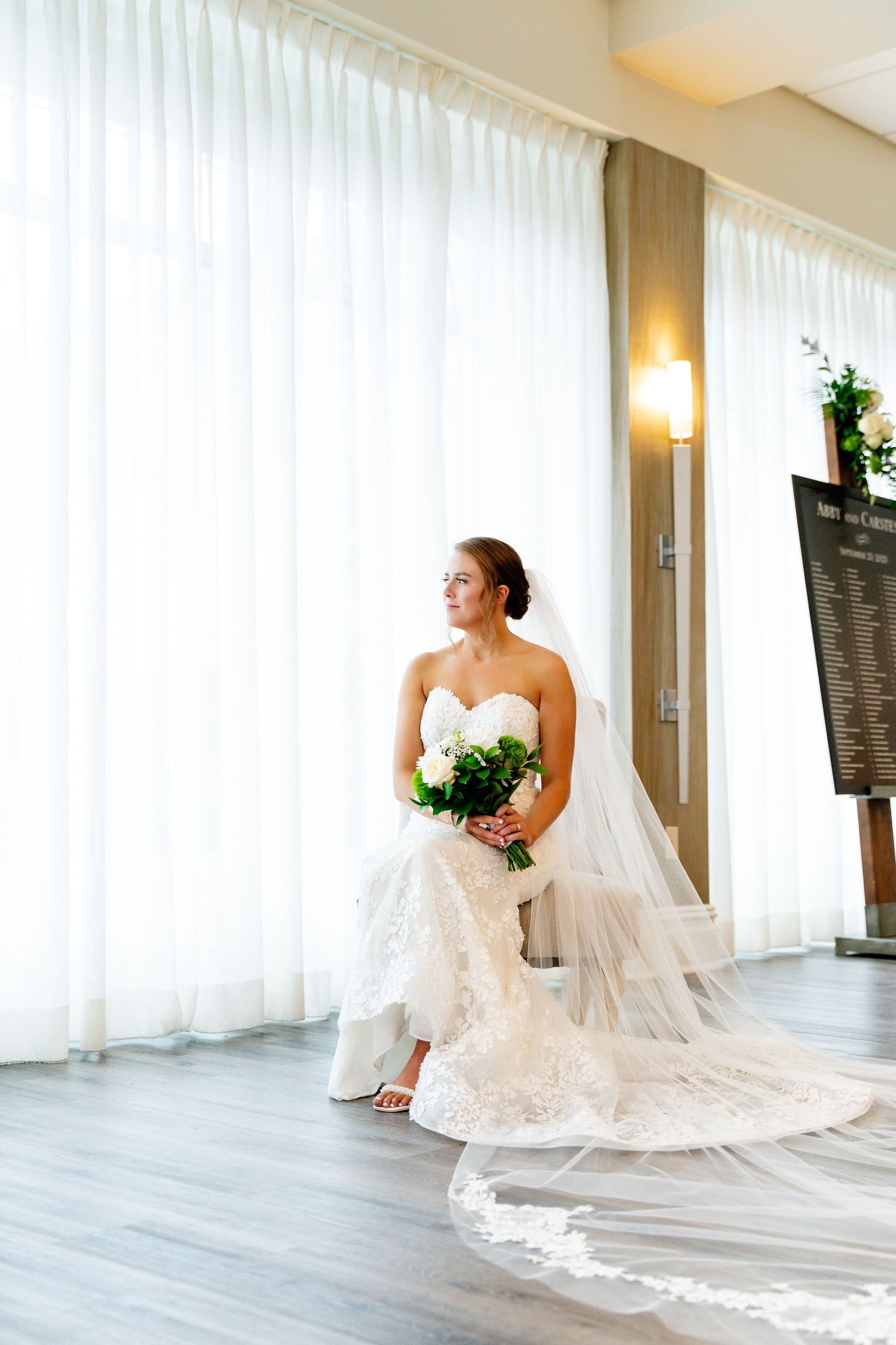 Elegant bridal portrait by white curtains in a modern venue.