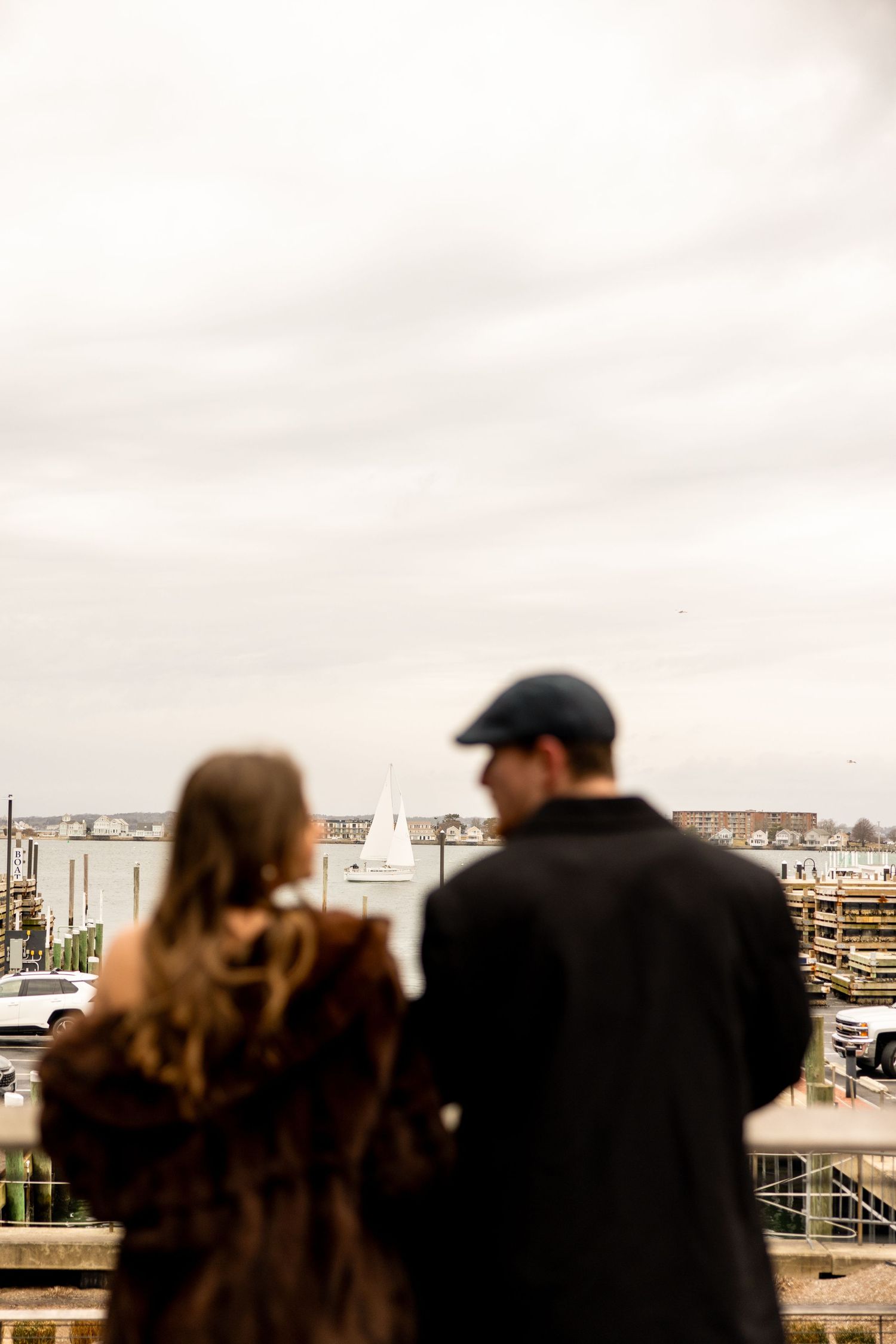 Couple standing on rooftop overlooking city skyline on overcast day.