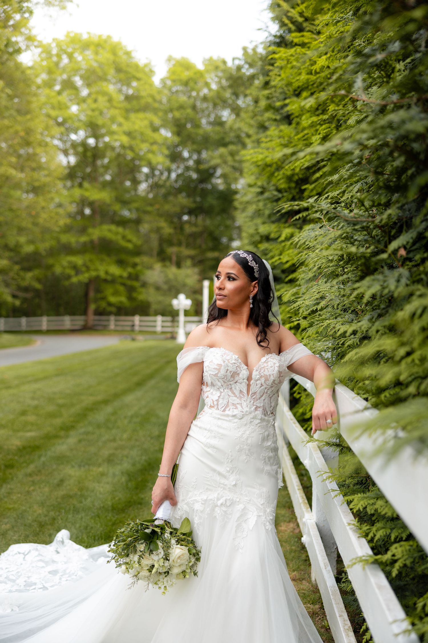 Wedding dress photographed in series of shots against a lush green garden backdrop with white fencing.
