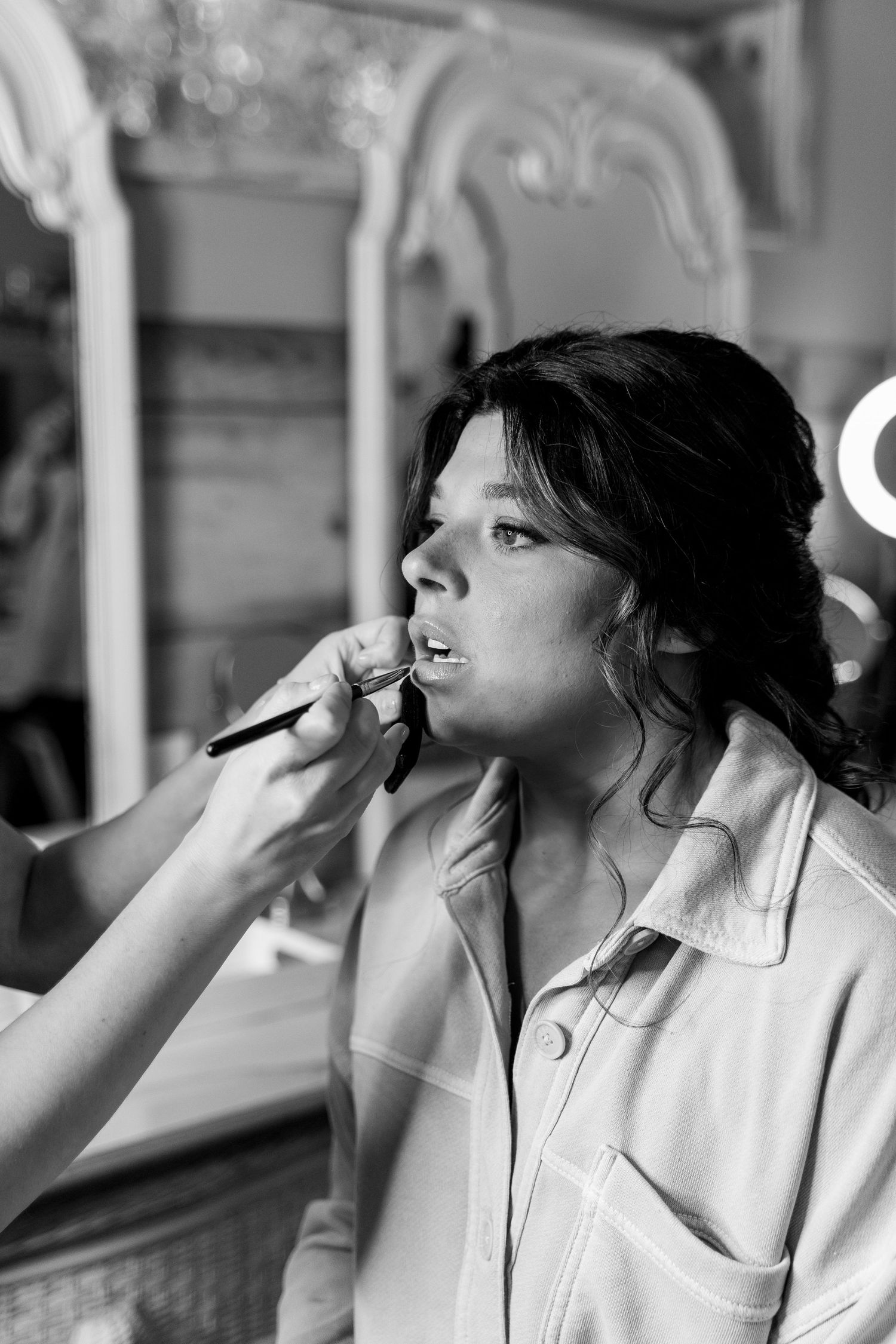 Makeup artist applies cosmetics during professional beauty preparation.