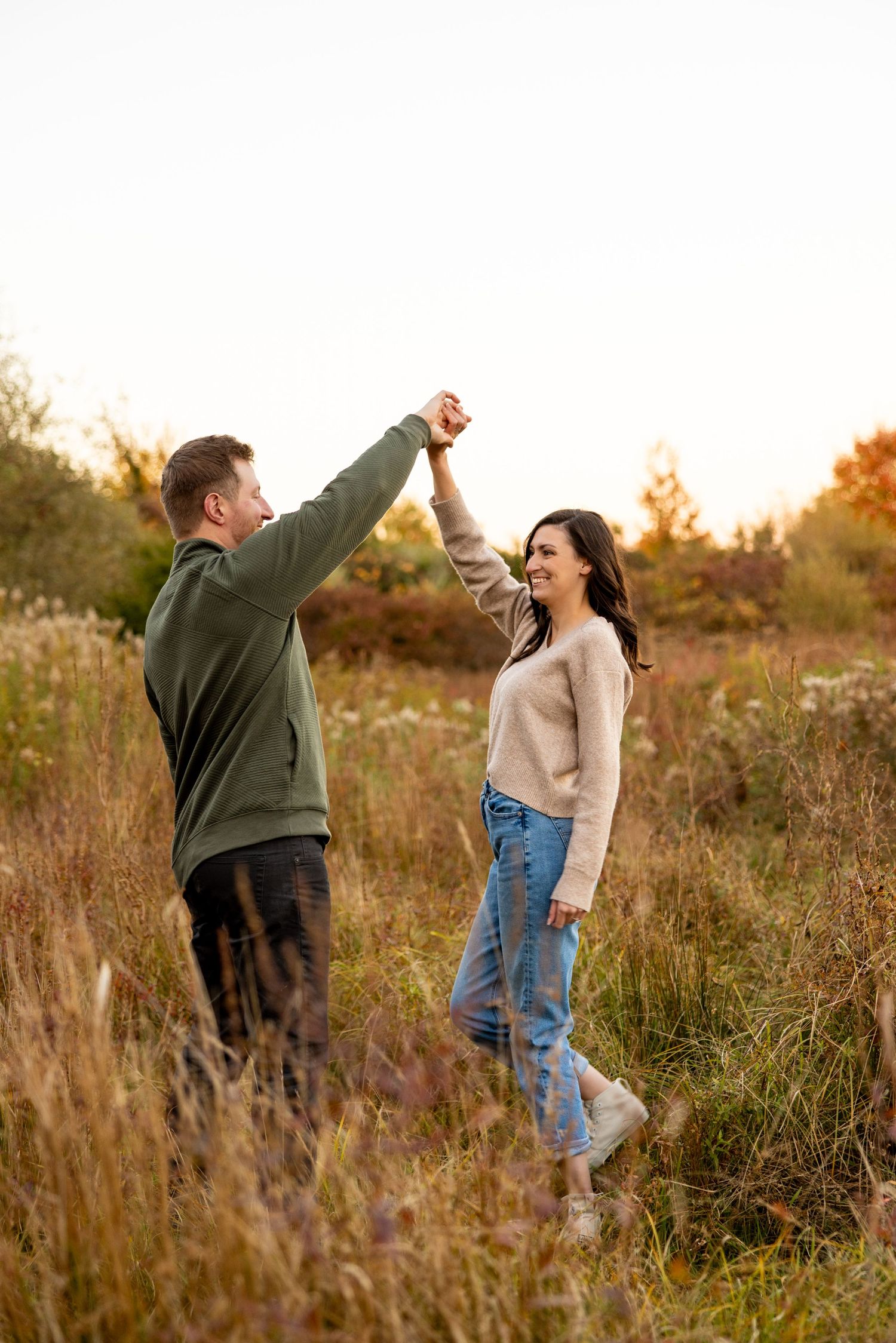 Fall engagement photo in a golden field at sunset.