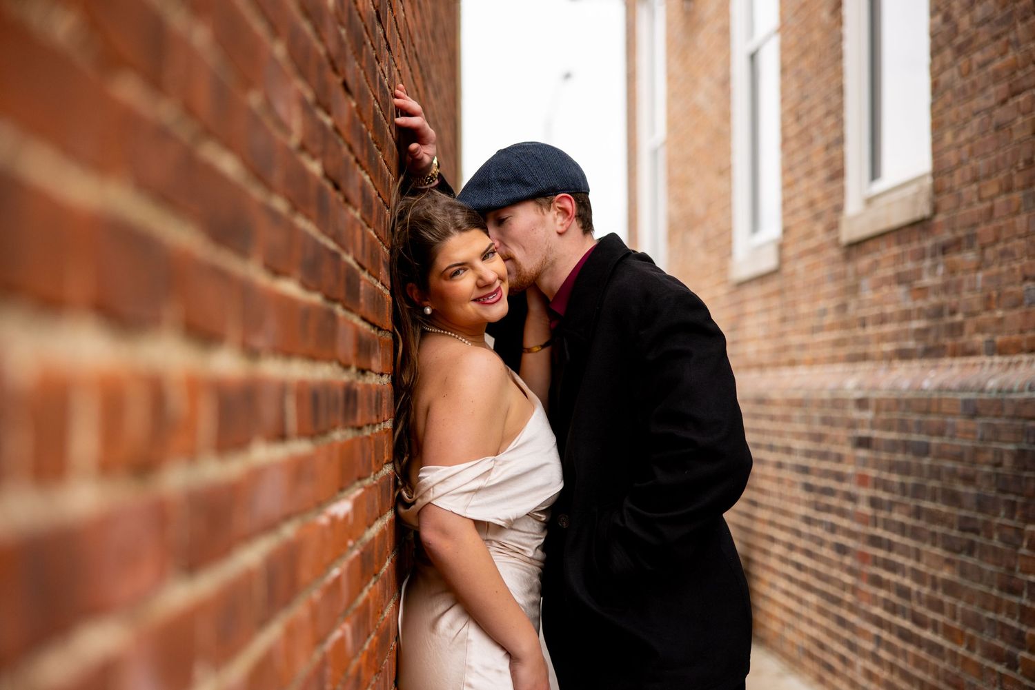 Intimate portrait against a brick wall showcasing romantic urban photography.