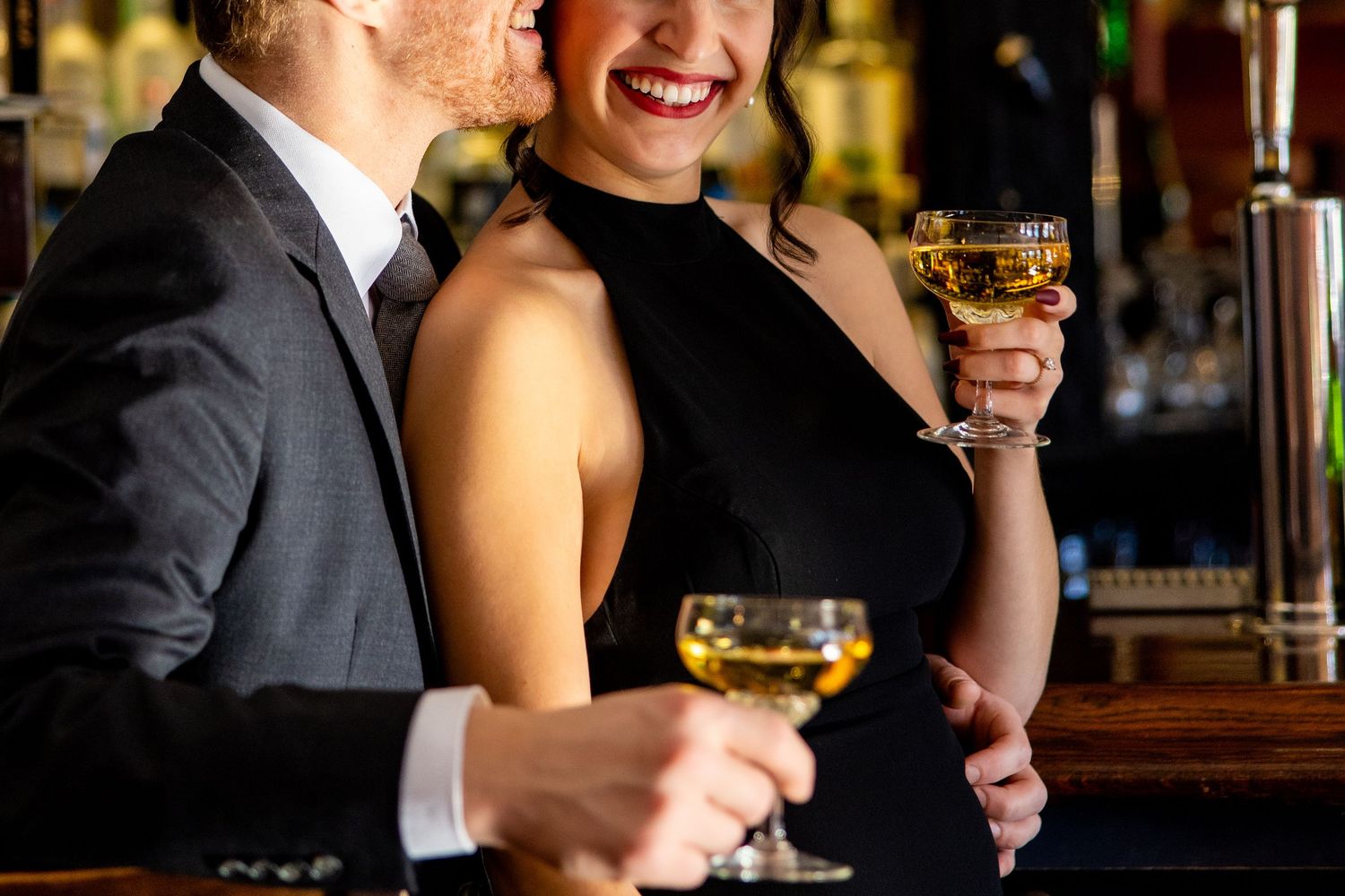 Close-up shot of couple enjoying wine together at an upscale bar.