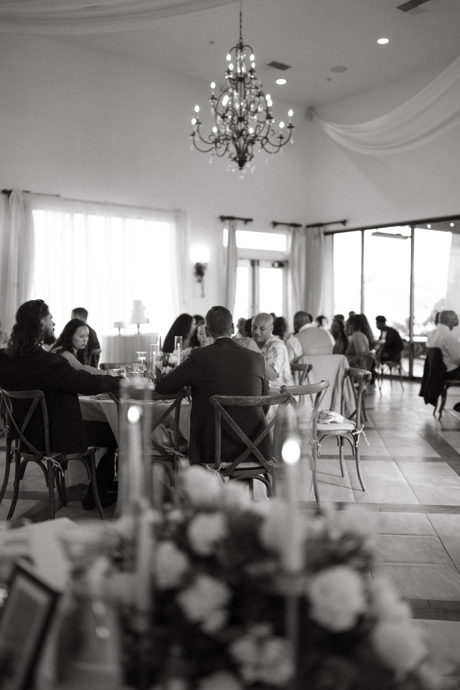 Elegant wedding reception venue with chandeliers and white decor.