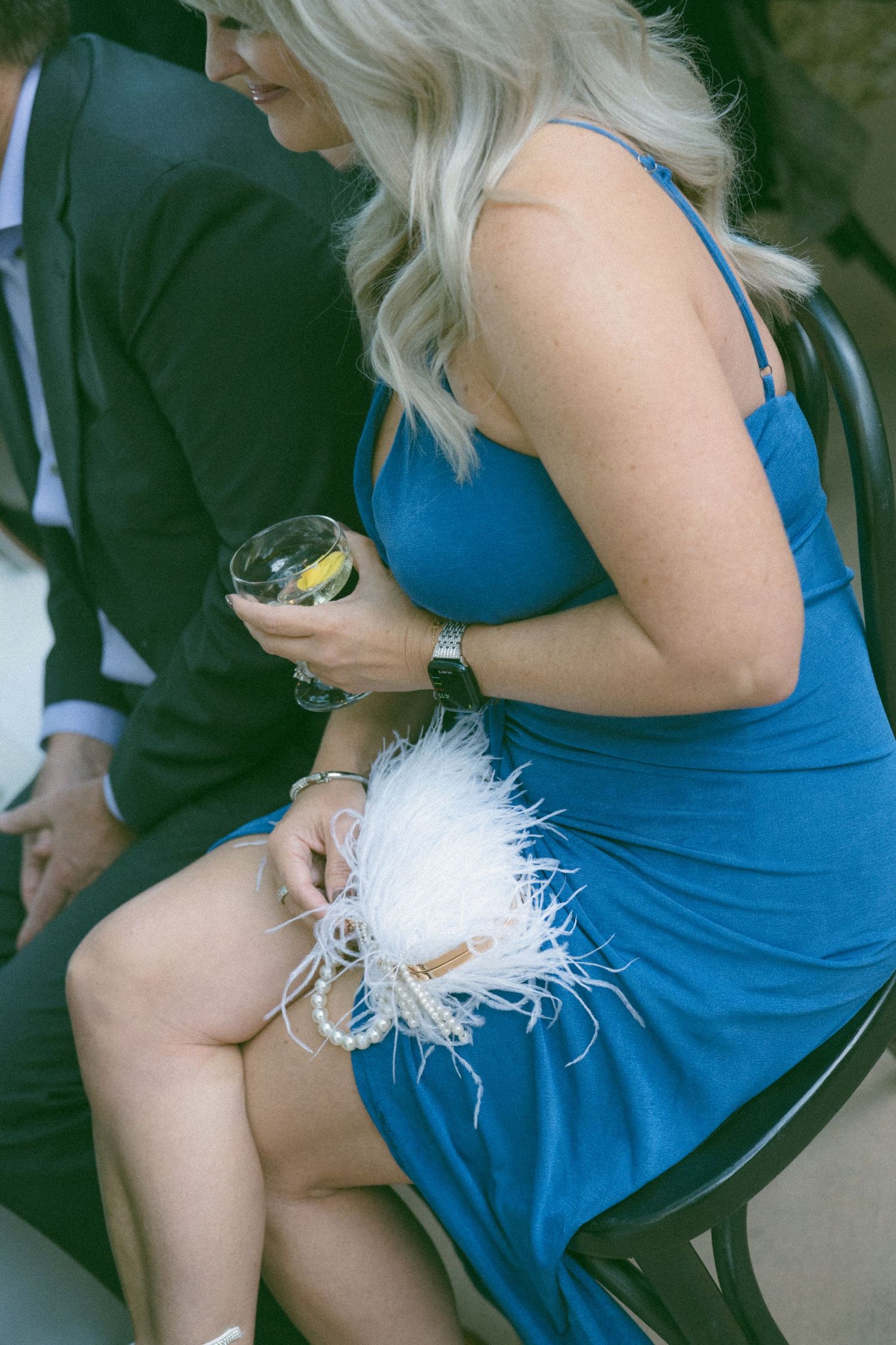 Wedding guests in formal attire seated during an outdoor celebration.