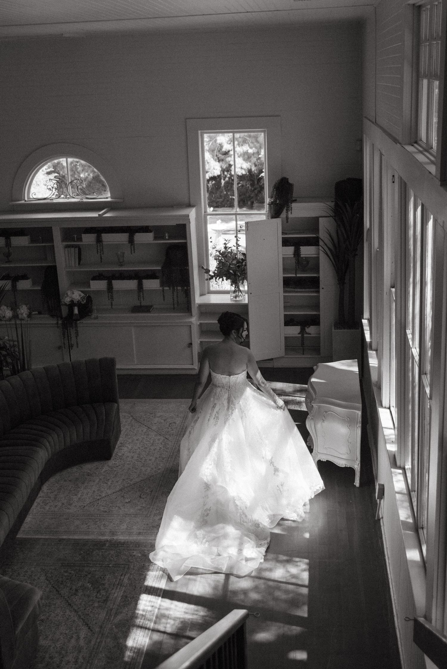 Black and white photo of wedding dress silhouette in window light.