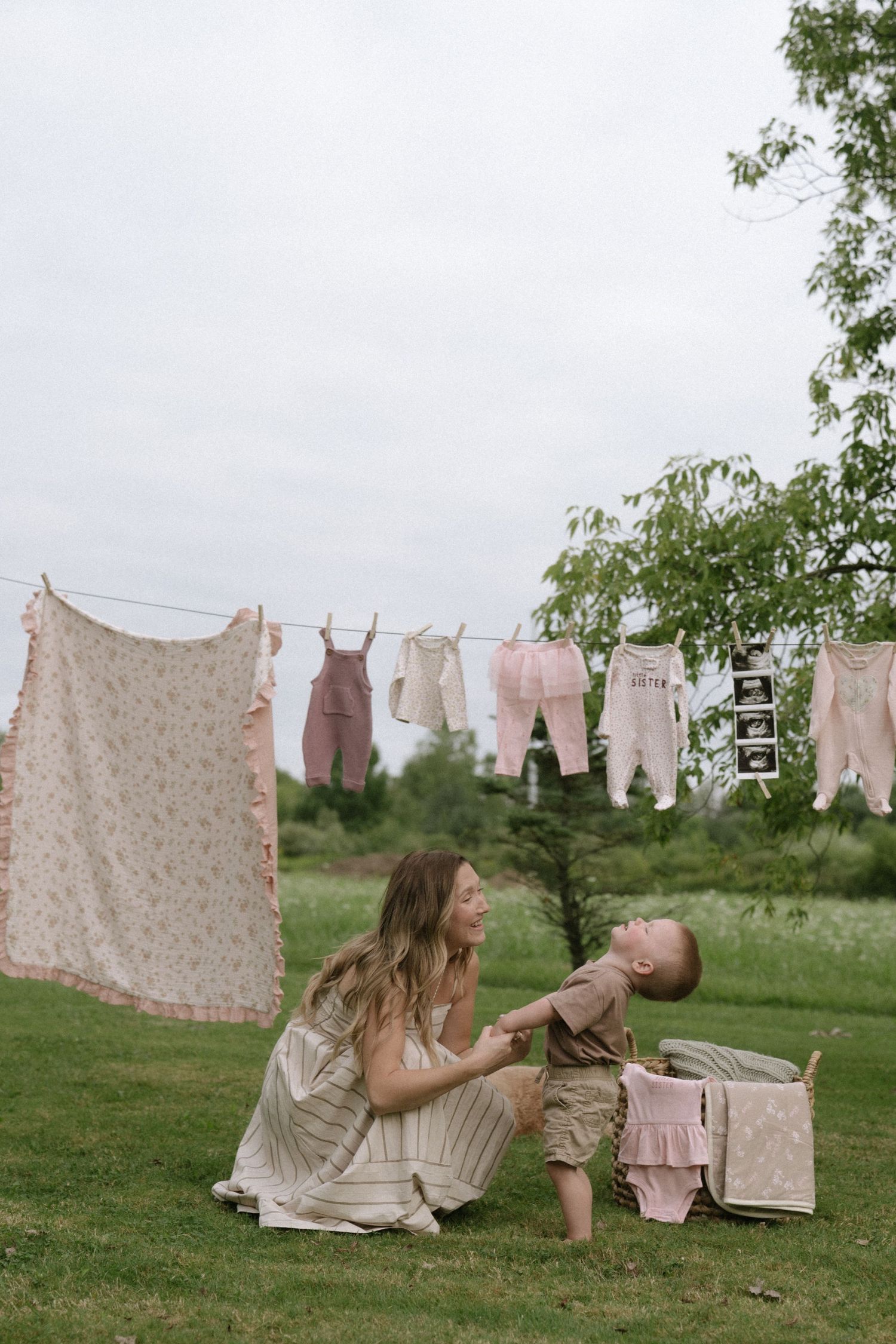 Clothesline with vintage linens and floral patterns hanging in a green field.