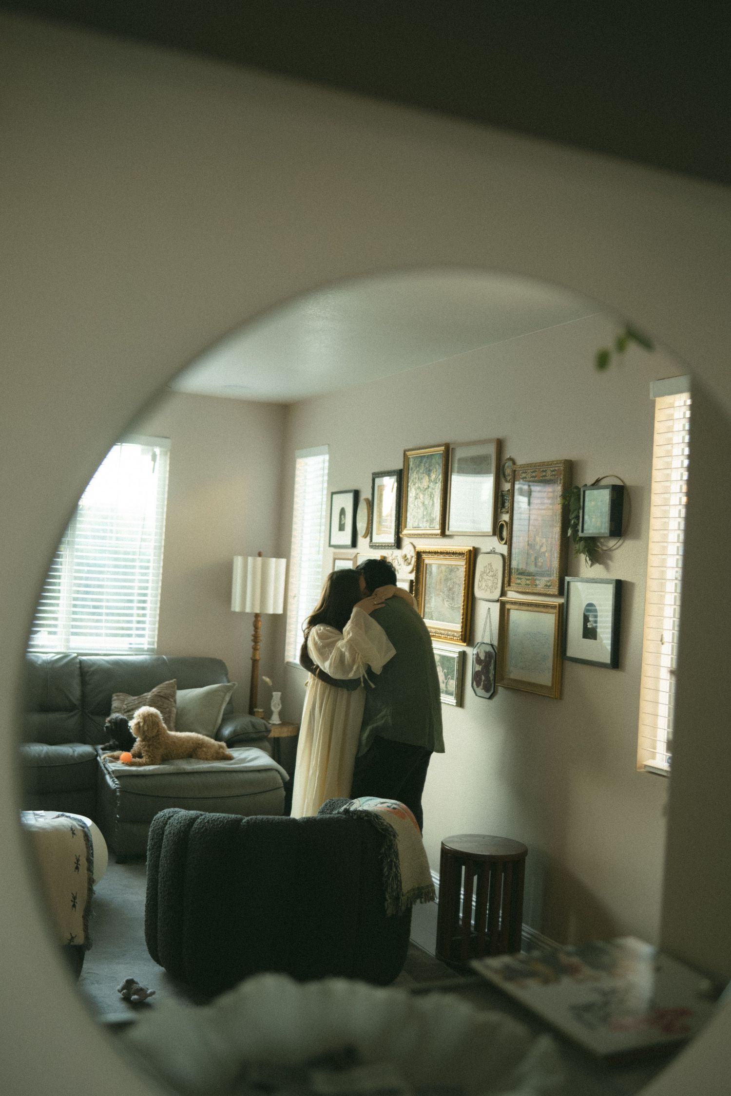 Interior view of a sunlit room with windows and framed artwork on the walls.