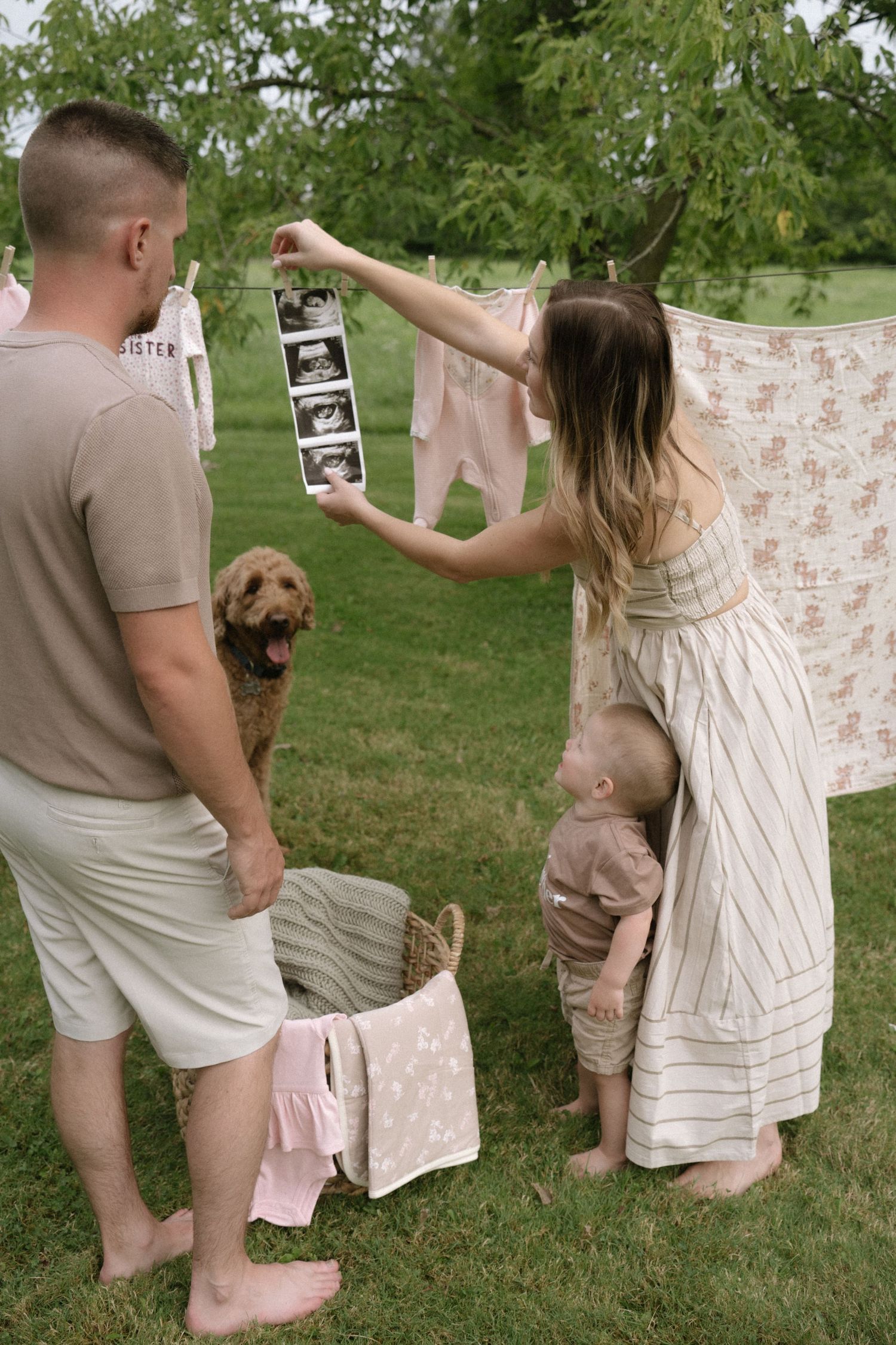 Family members hanging laundry together on an outdoor clothesline.
