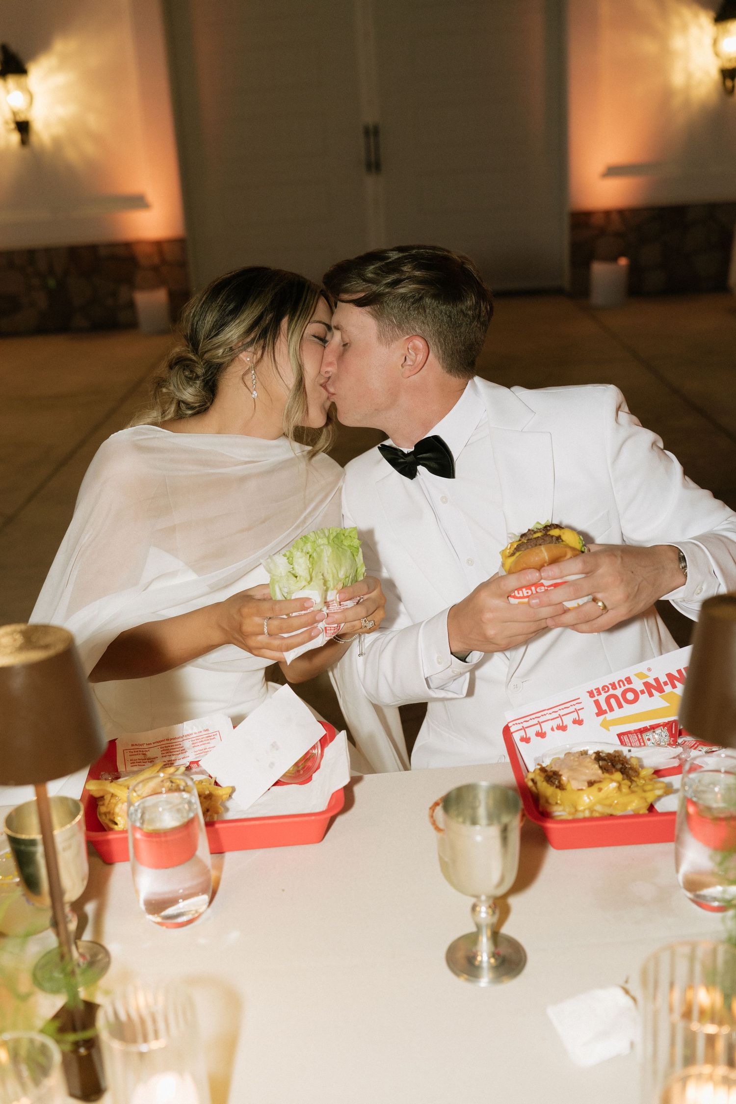 Newlyweds enjoying In-N-Out burger takeout at their wedding reception.