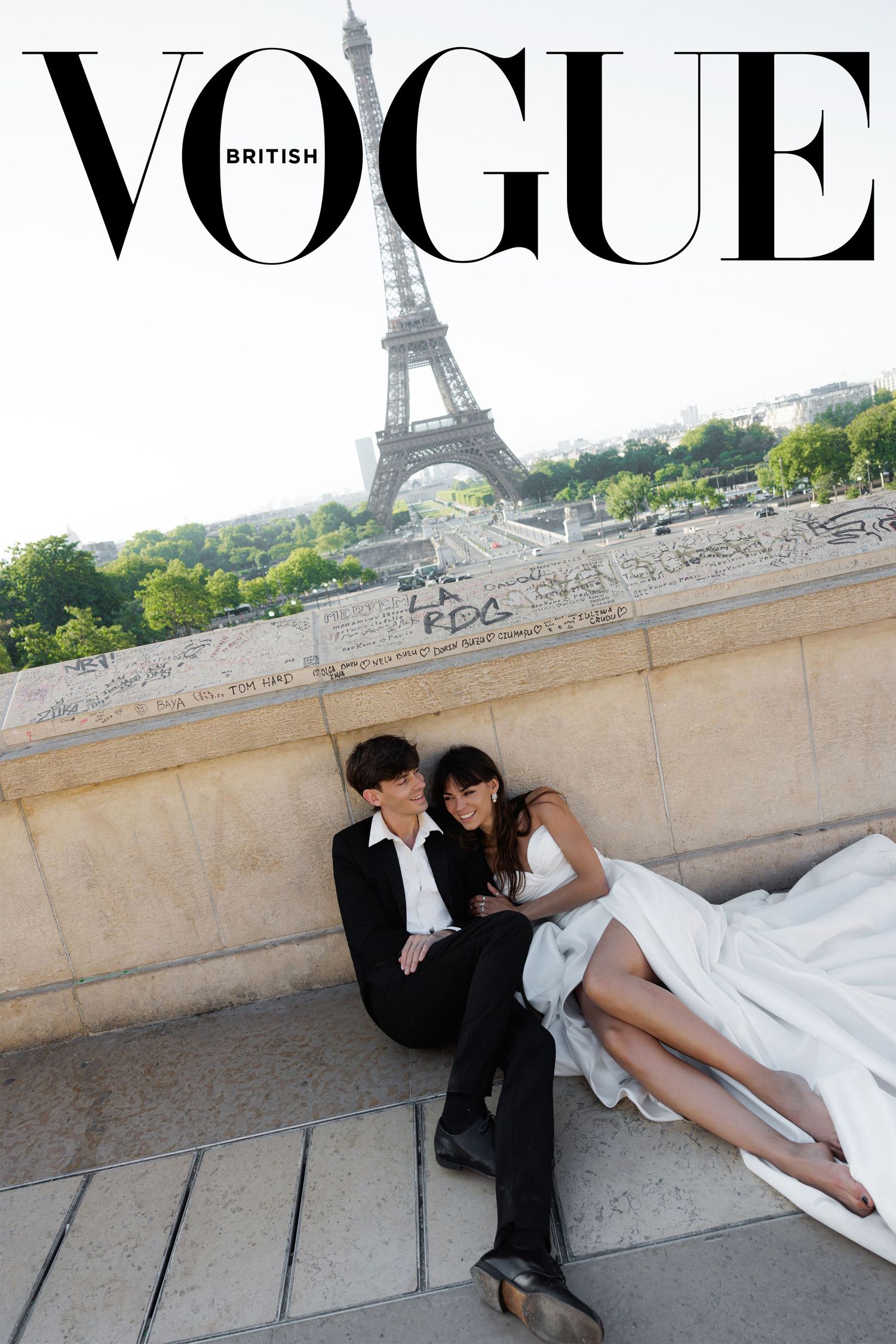 British Vogue cover featuring wedding couple relaxing on steps near the Eiffel Tower.