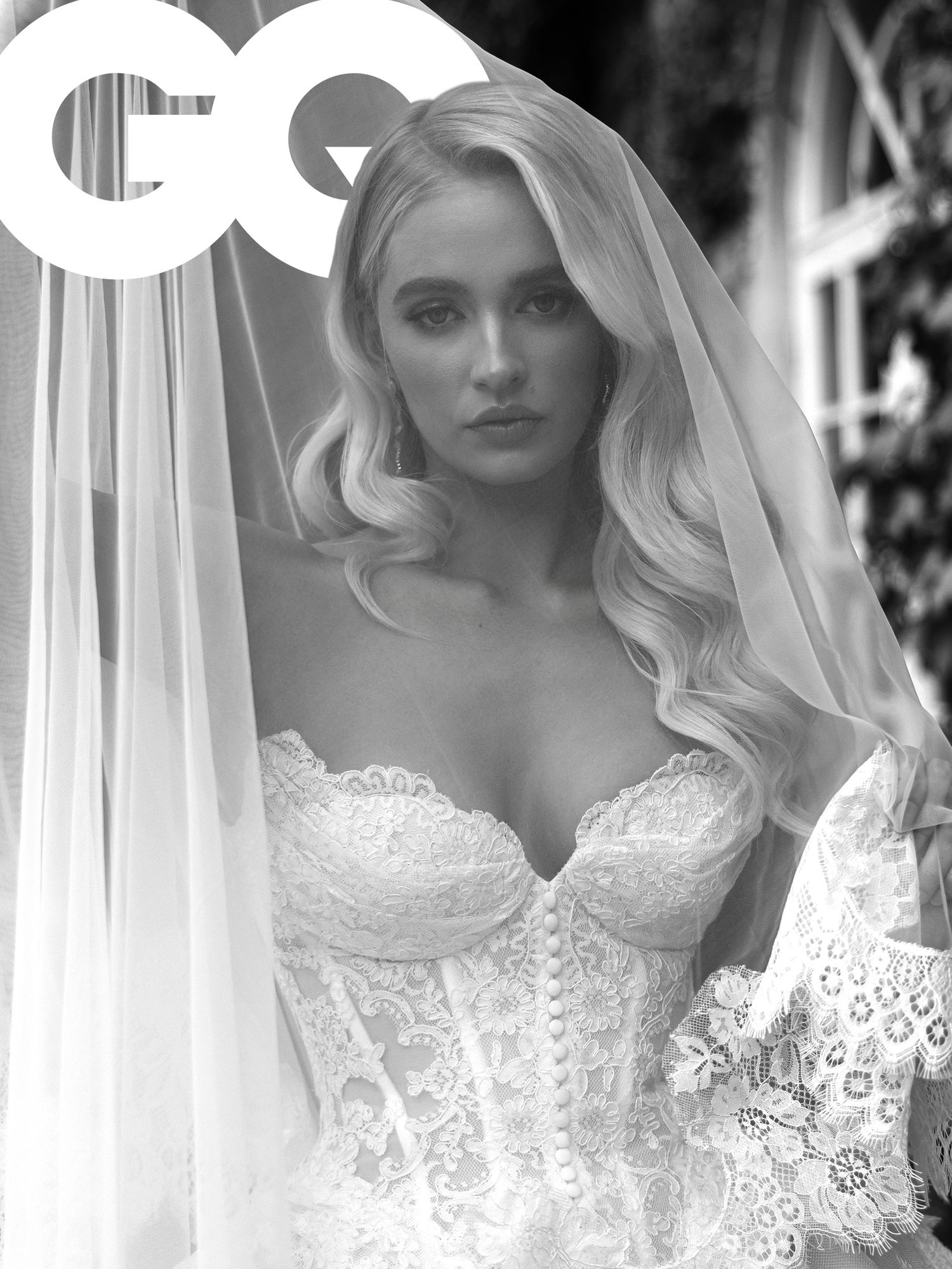 Bride in elegant lace wedding gown and veil poses for GQ magazine cover in black and white photo.