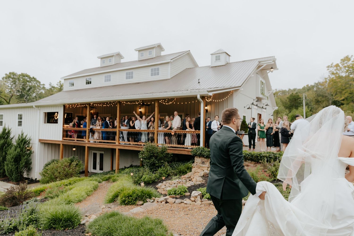 Wedding venue exterior shots showing white farmhouse-style building and outdoor ceremony space in Tennessee.