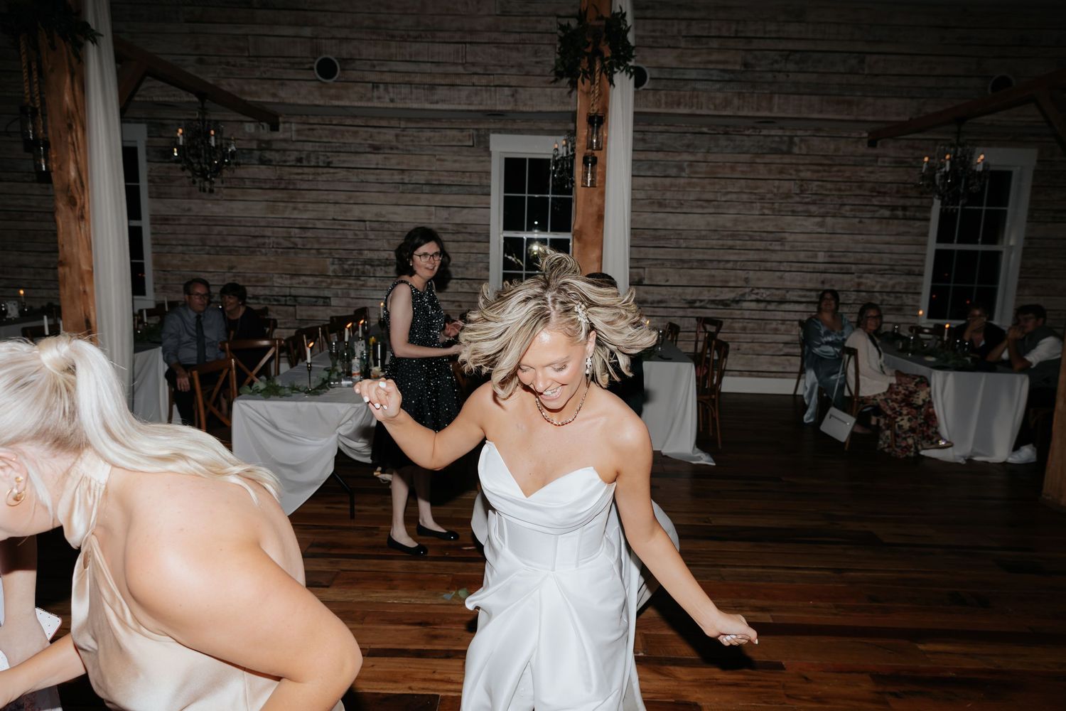 Bride dancing during reception in a rustic barn in Tennessee.