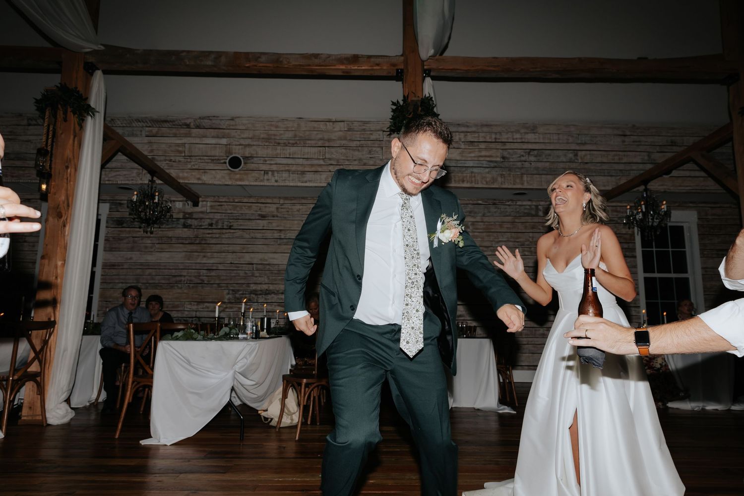 Groom dancing during indoor barn wedding reception in Tennessee.