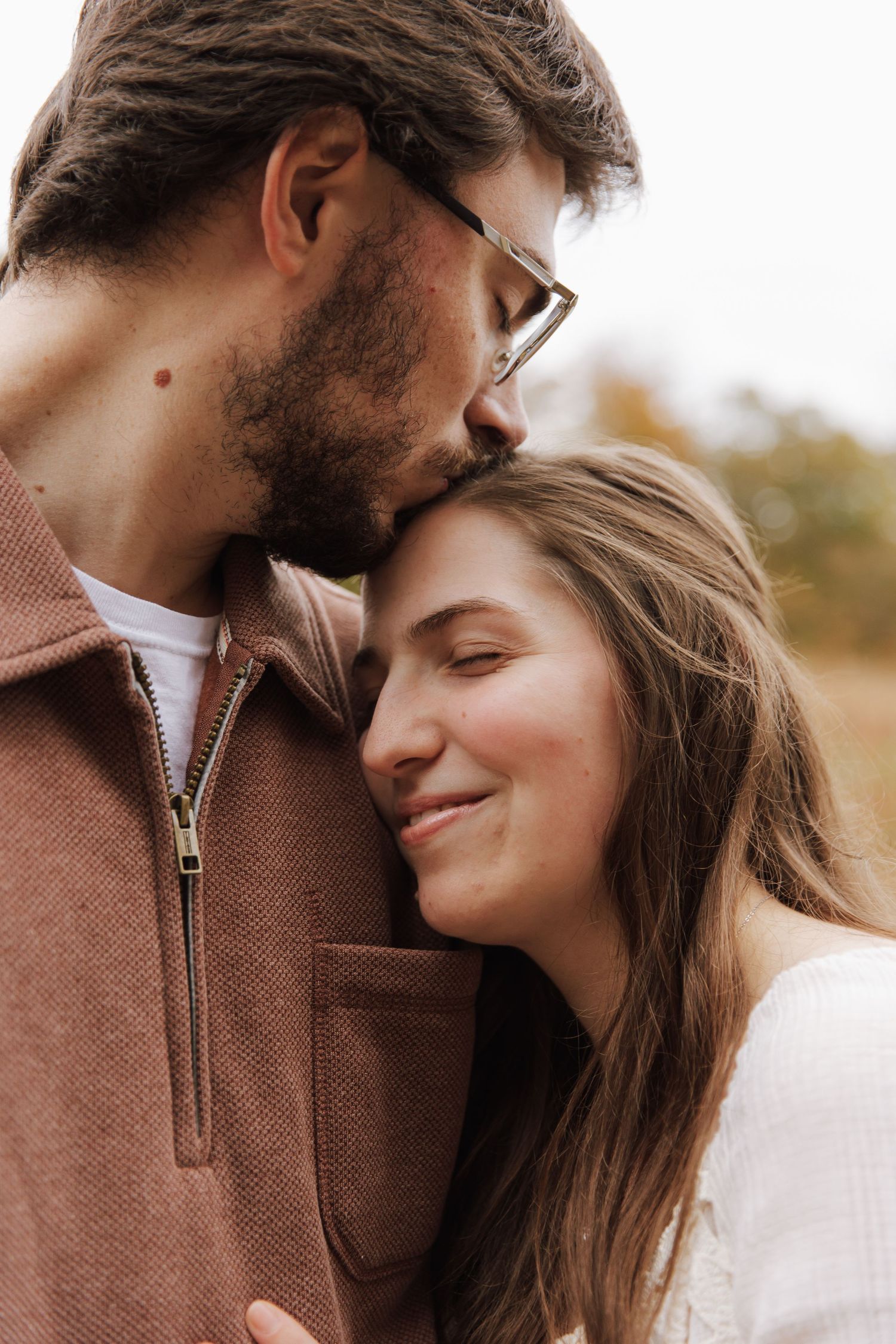 A romantic couple embraces in a series of tender close-up shots outdoors during autumn.