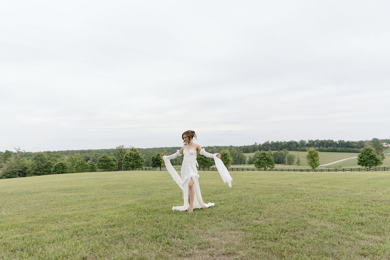 A scenic view of an open grassy field with distant trees on a bright sunny day.