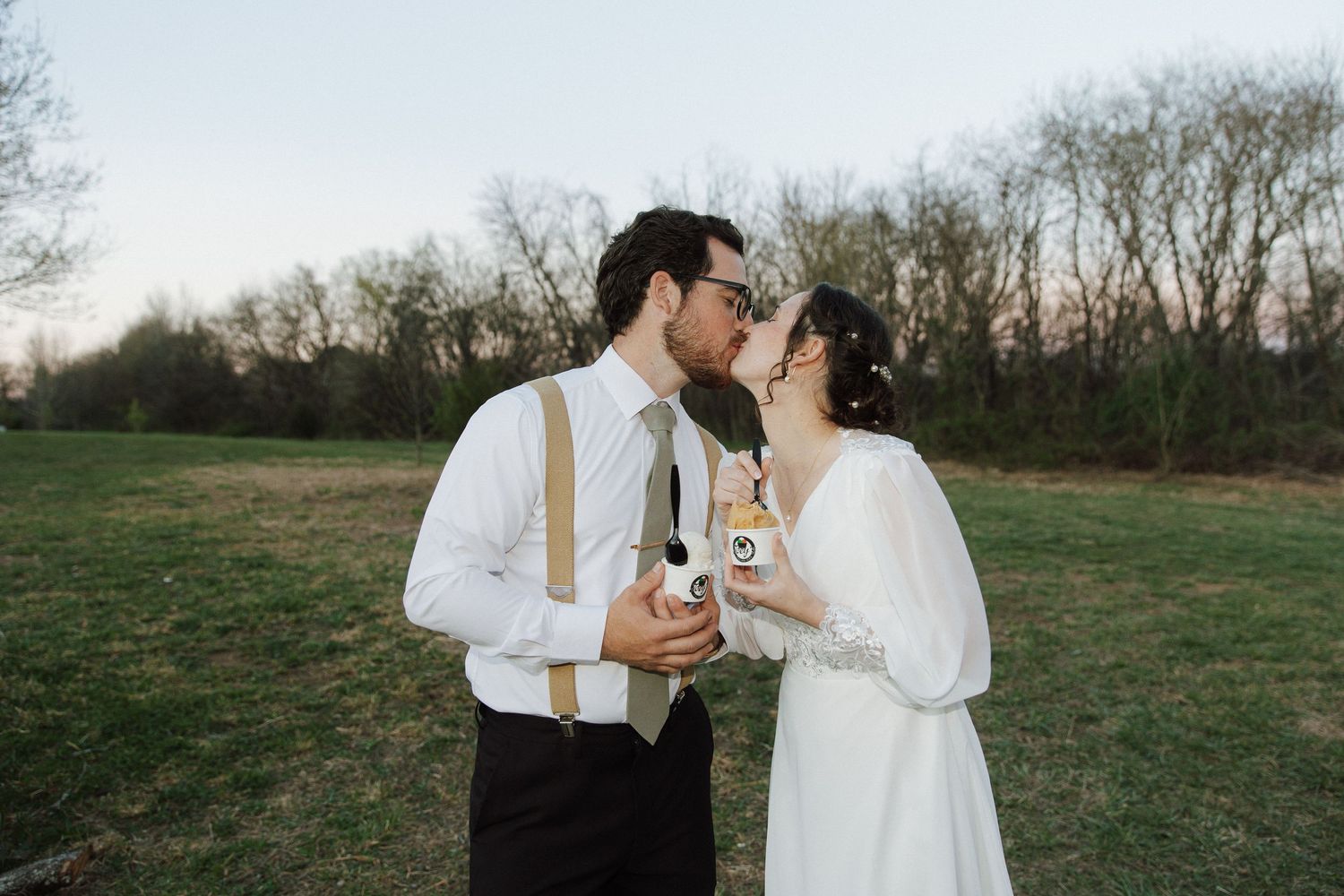Romantic outdoor wedding portraits in a field with natural lighting and candid moments.