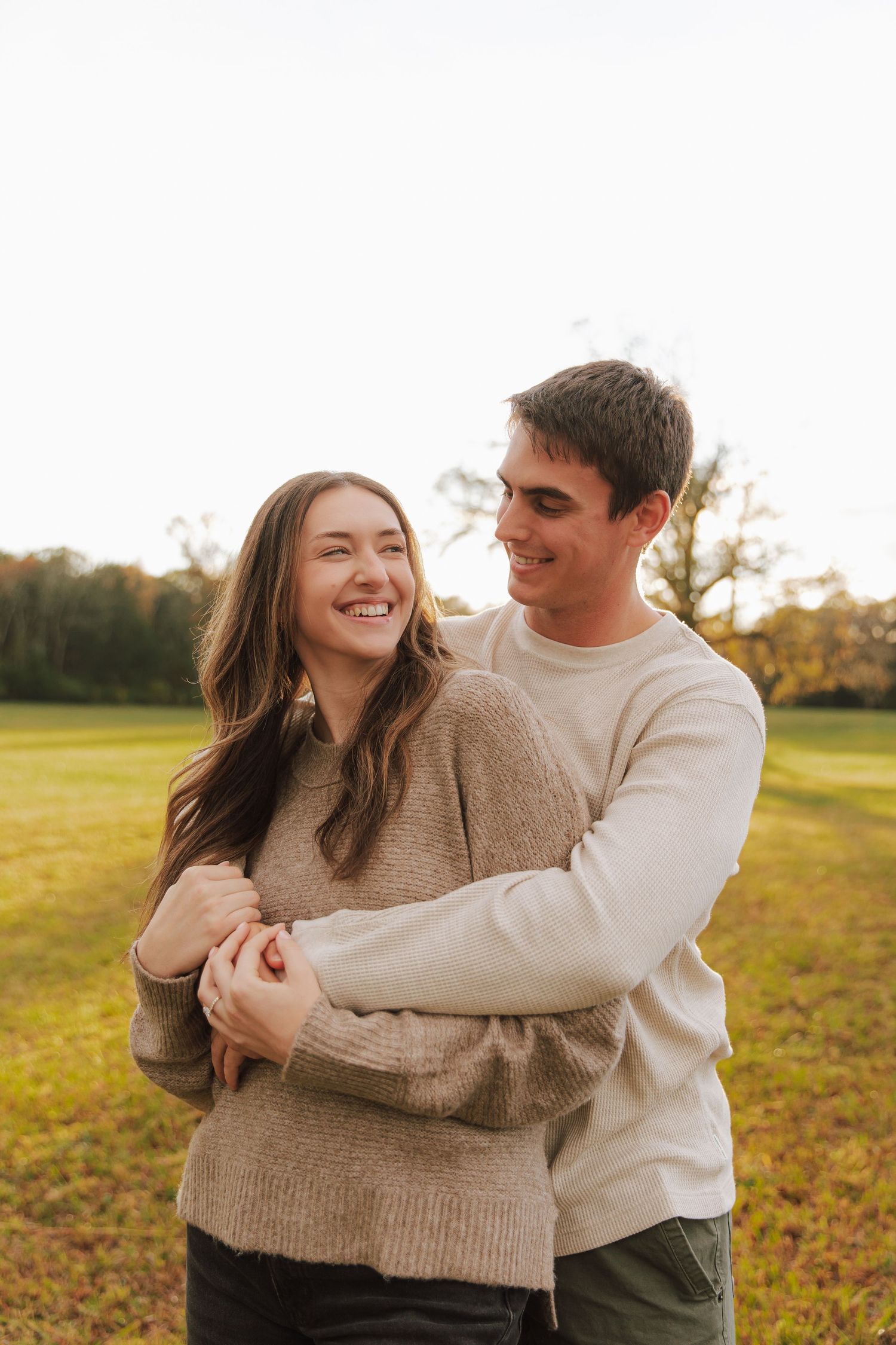 Couple sharing tender moments in a golden field during sunset.