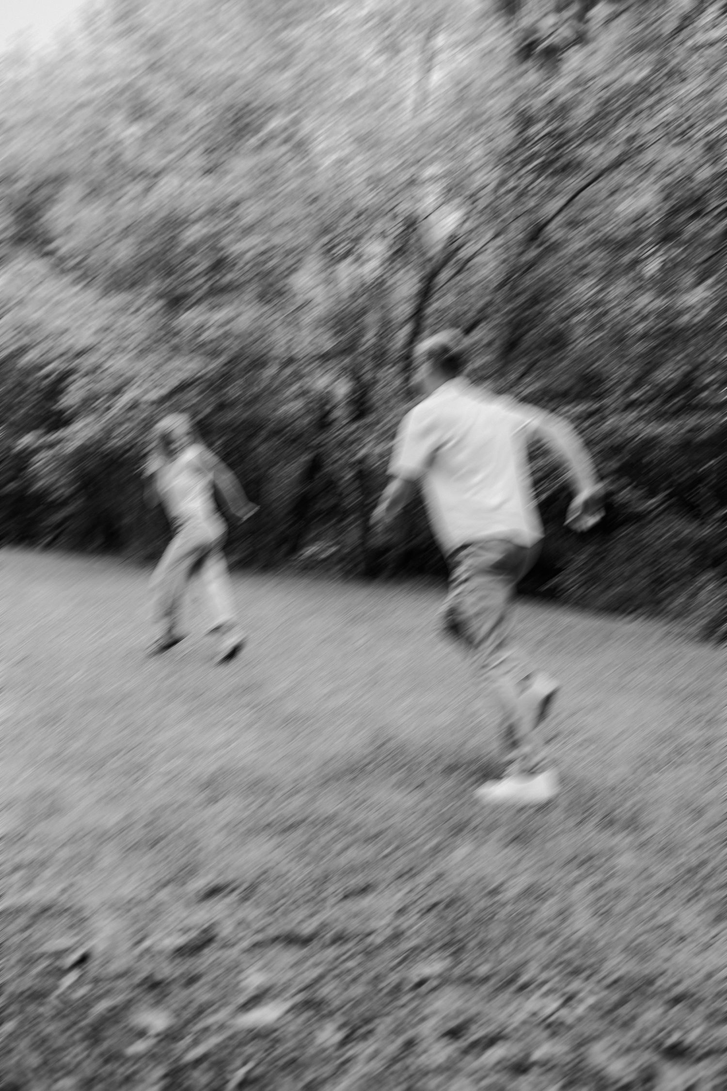 A sequence of black and white photos showing people playing soccer on a grassy slope in a natural outdoor setting.