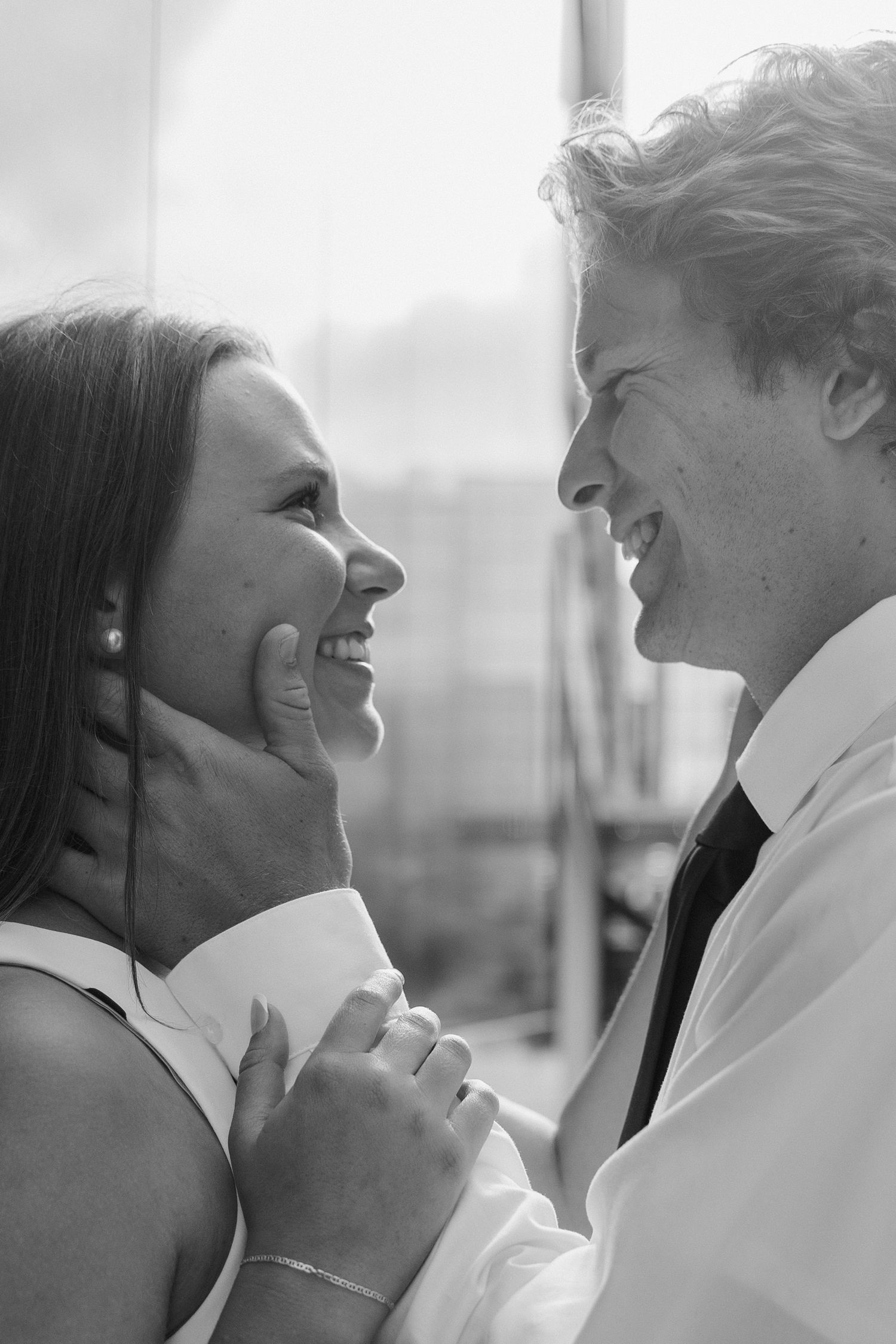 Black and white portrait of a couple sharing a joyful moment together.