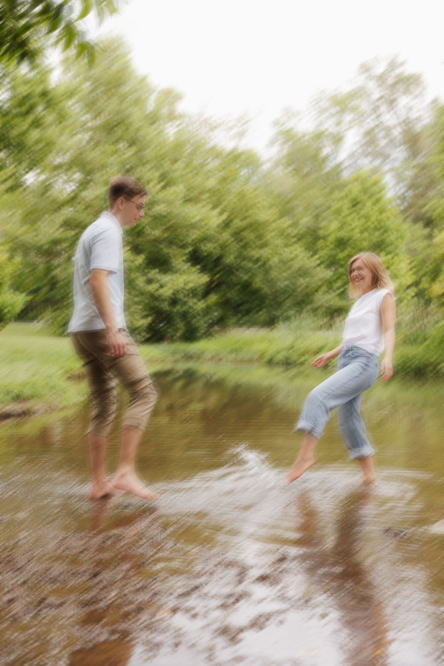 Motion-blurred sequence of people splashing and playing in shallow water on a sunny summer day.