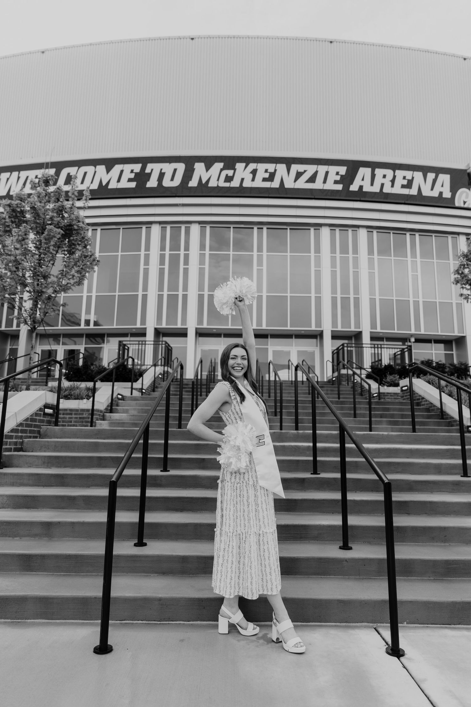 A series of black and white photos showing someone posing on steps outside McKenzie Arena in a floral dress.