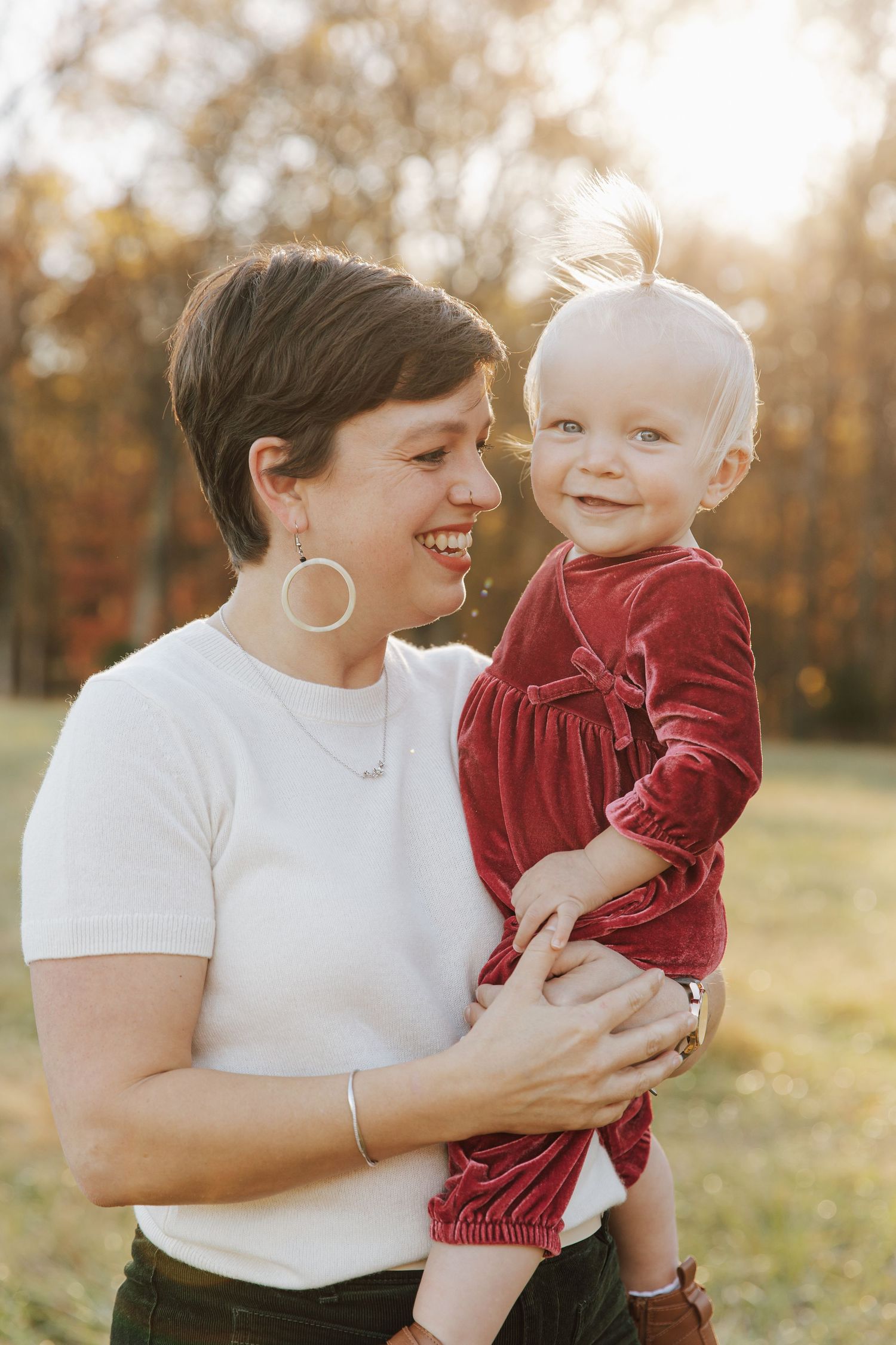 A heartwarming outdoor photo session showing tender moments between parent and child in autumn sunlight.