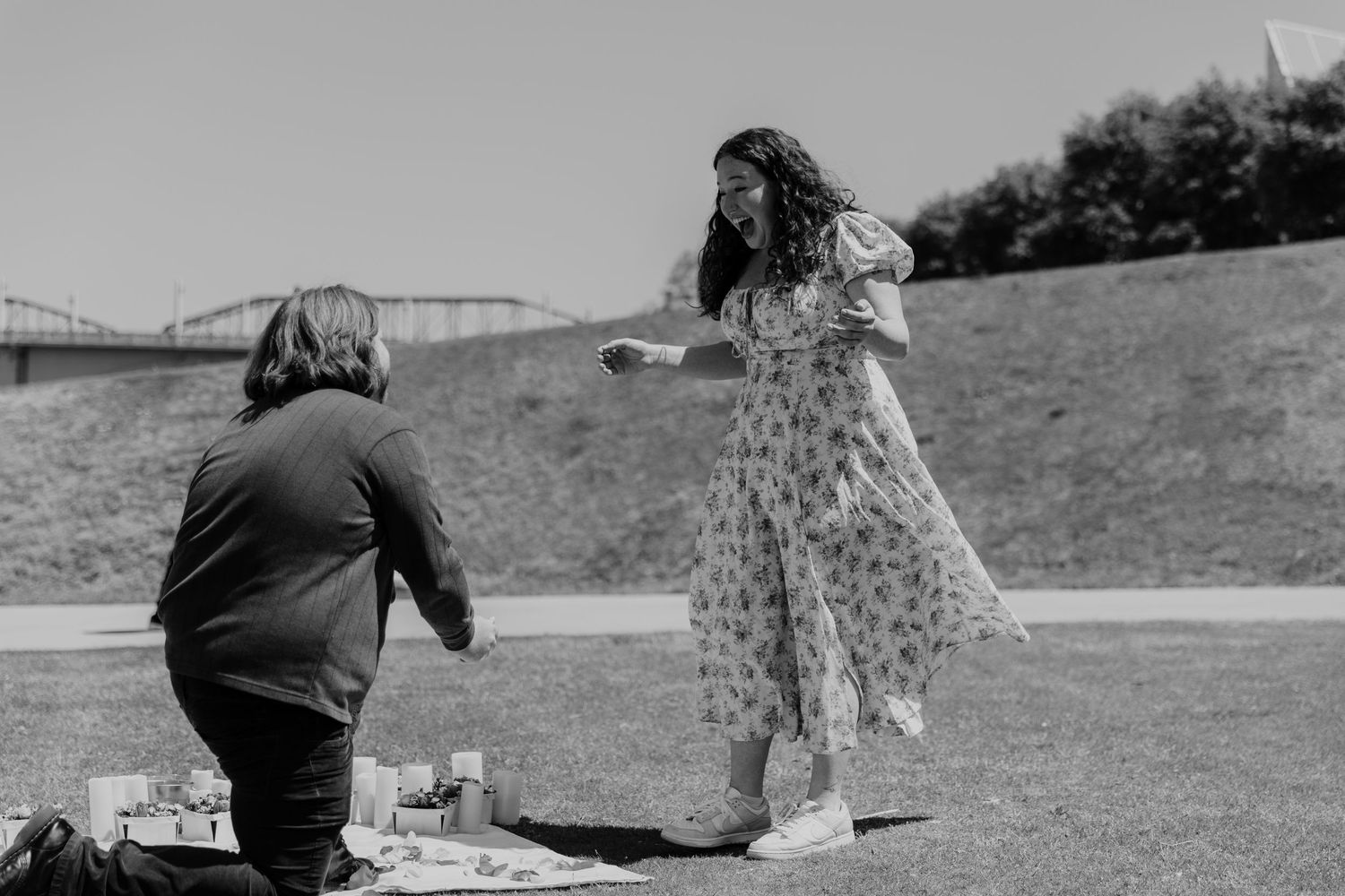 Artistic black and white photo of couple sitting together outdoors.