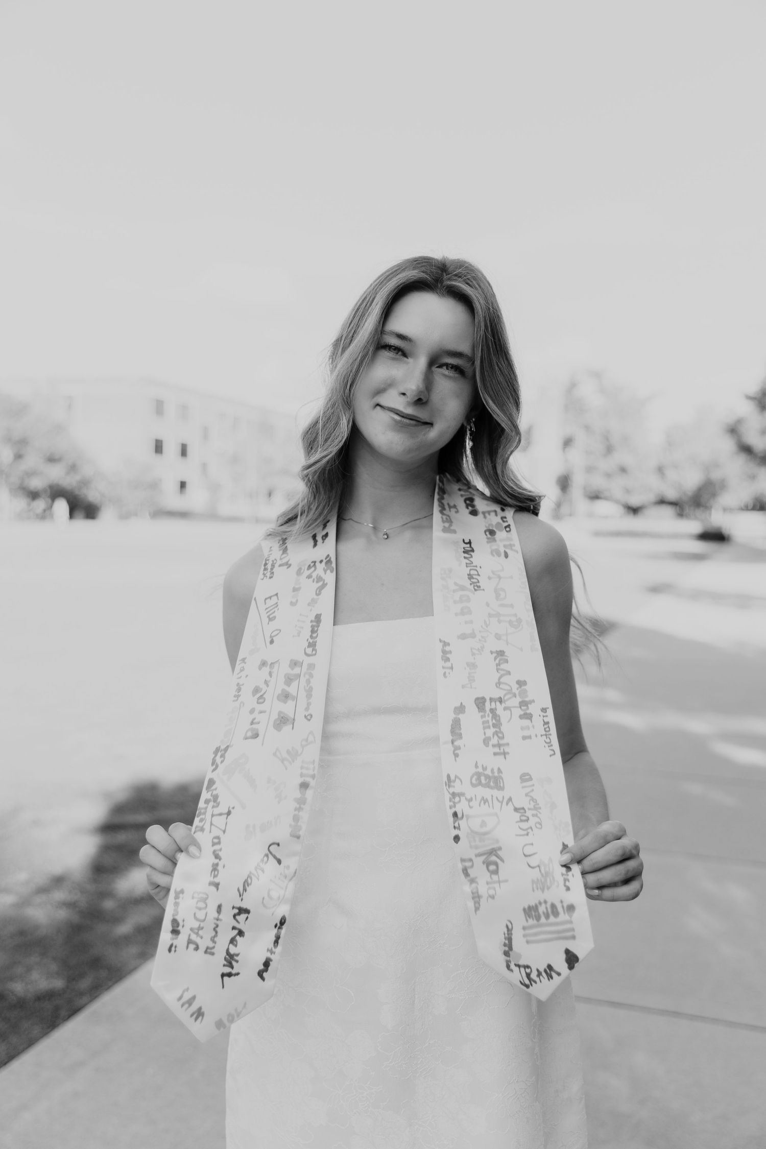 Black and white series featuring a white dress with decorative details in an outdoor setting.