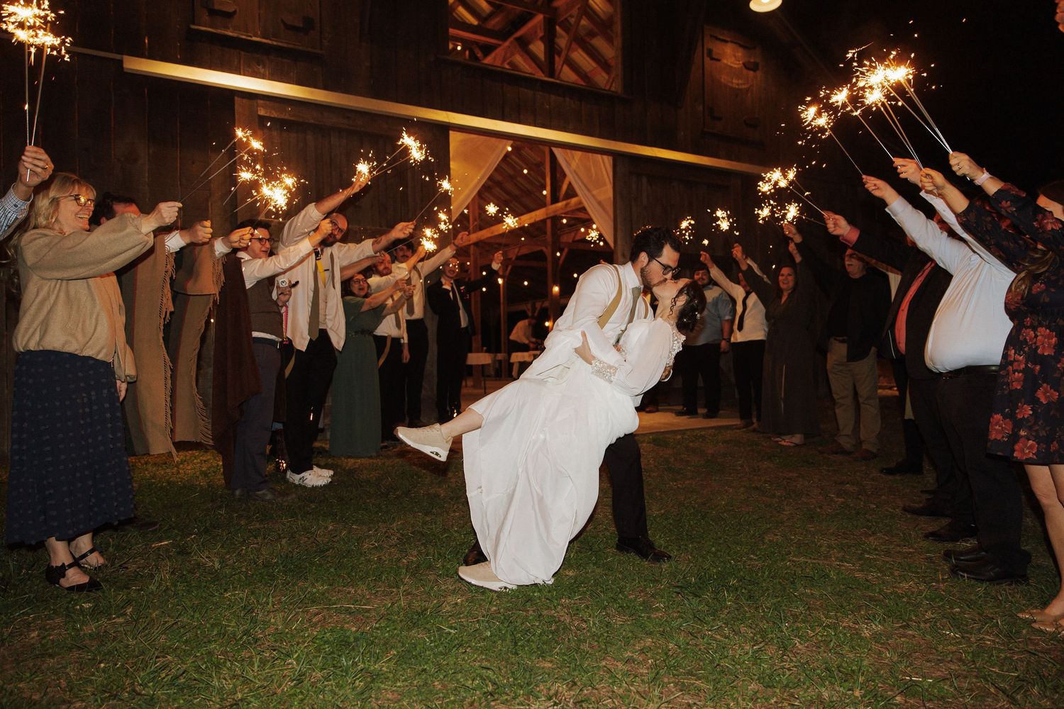 Wedding sparkler exit celebration with guests creating a magical light tunnel.