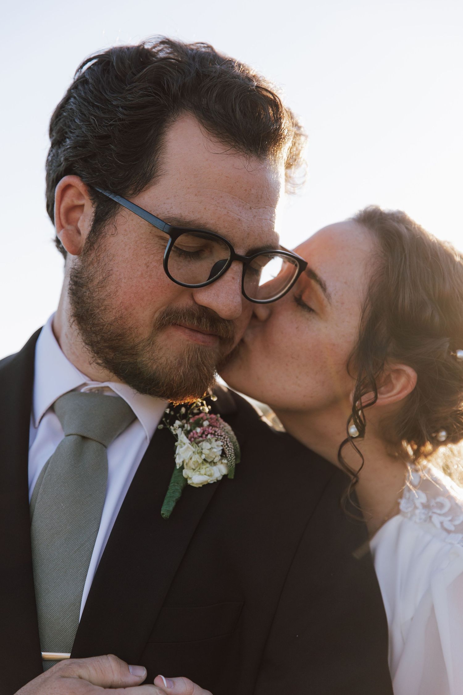 Intimate sunset wedding portrait with soft golden light and natural expressions.