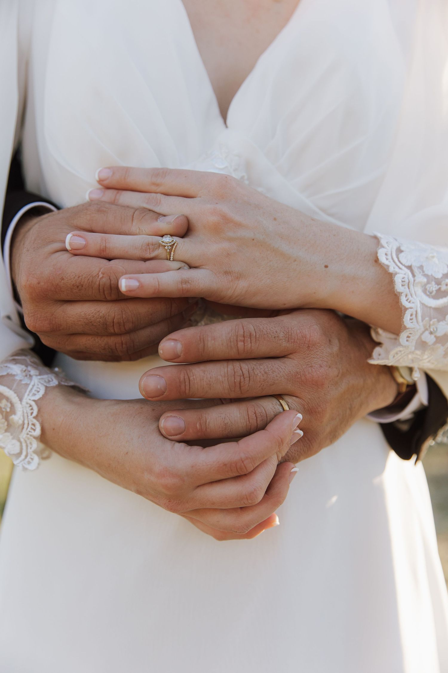Close-up detail shots of hands with wedding rings and lace dress details.