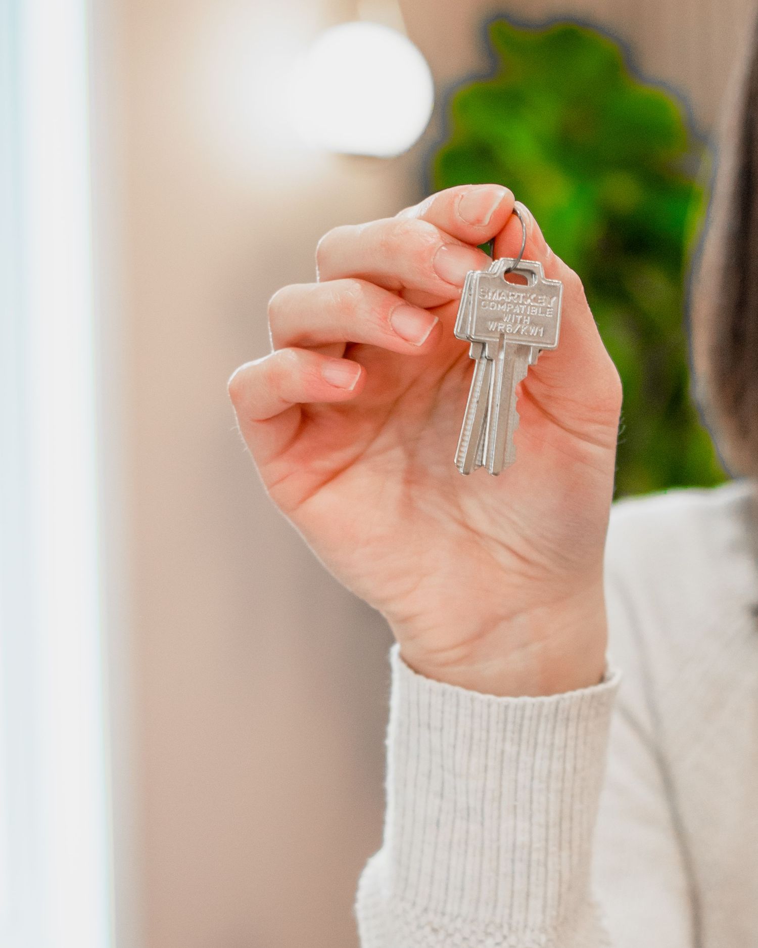 A hand holds a set of house keys.