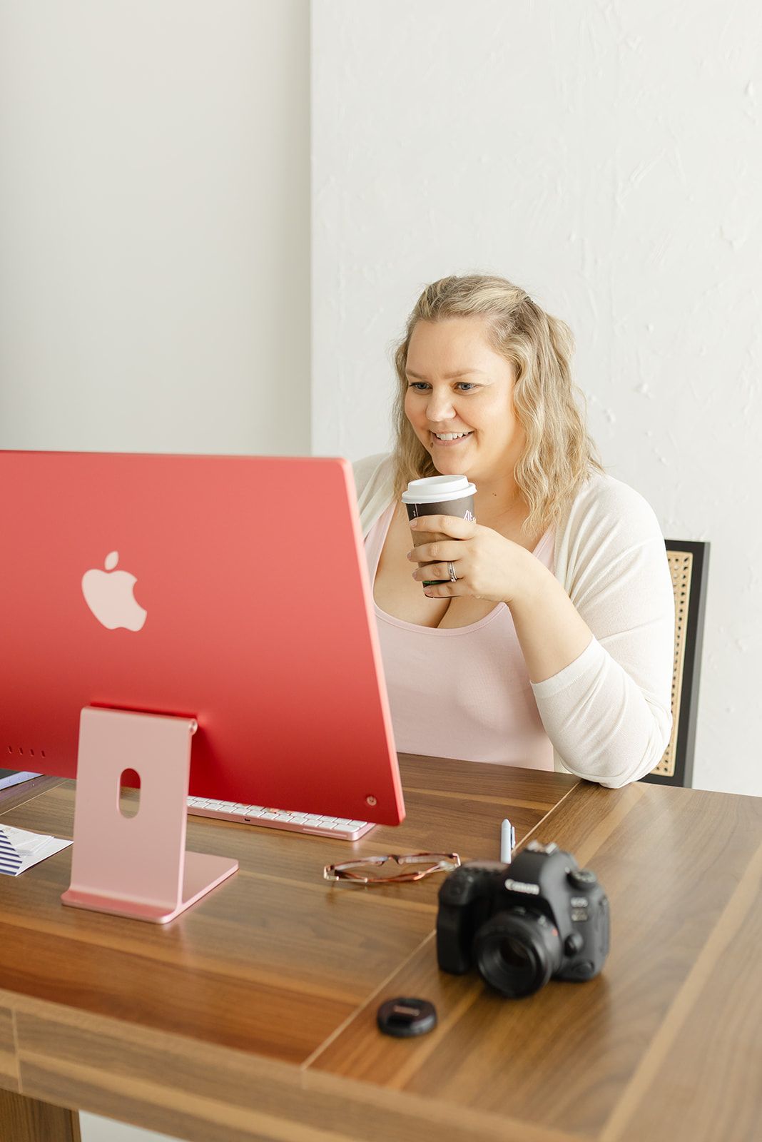 Image of a computer keyboard and mouse on a wooden desk, with a pink desk organizer visible.