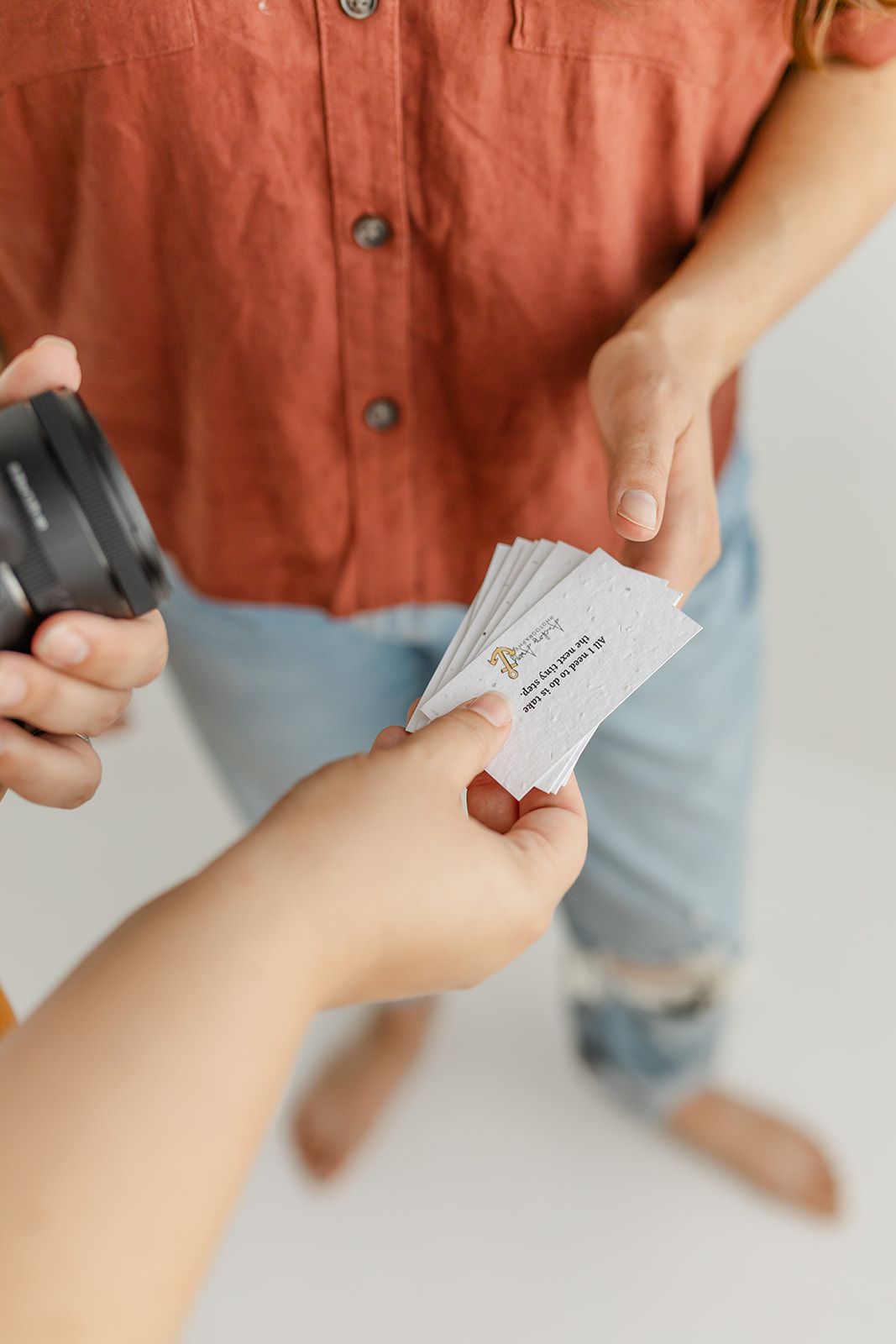 A person's hand holding a business card or document.