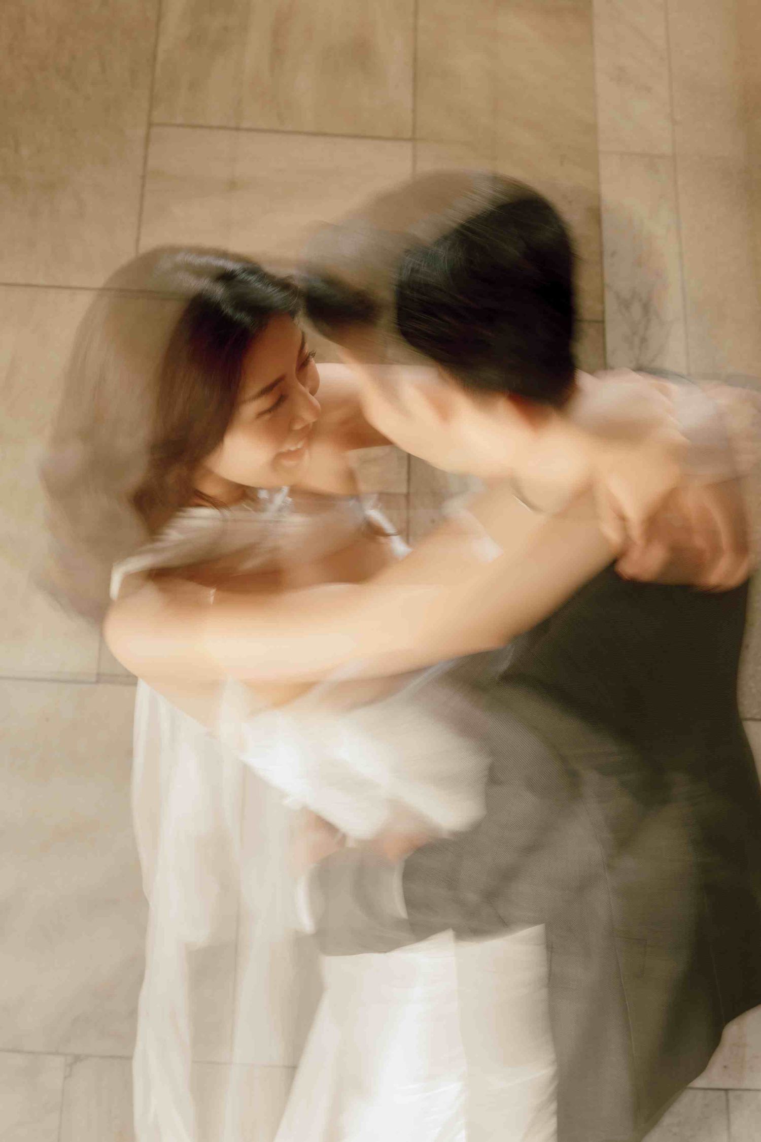 A timeless, blurred elopement photo of a couple dancing together on a tiled floor, captured at New York Public Library