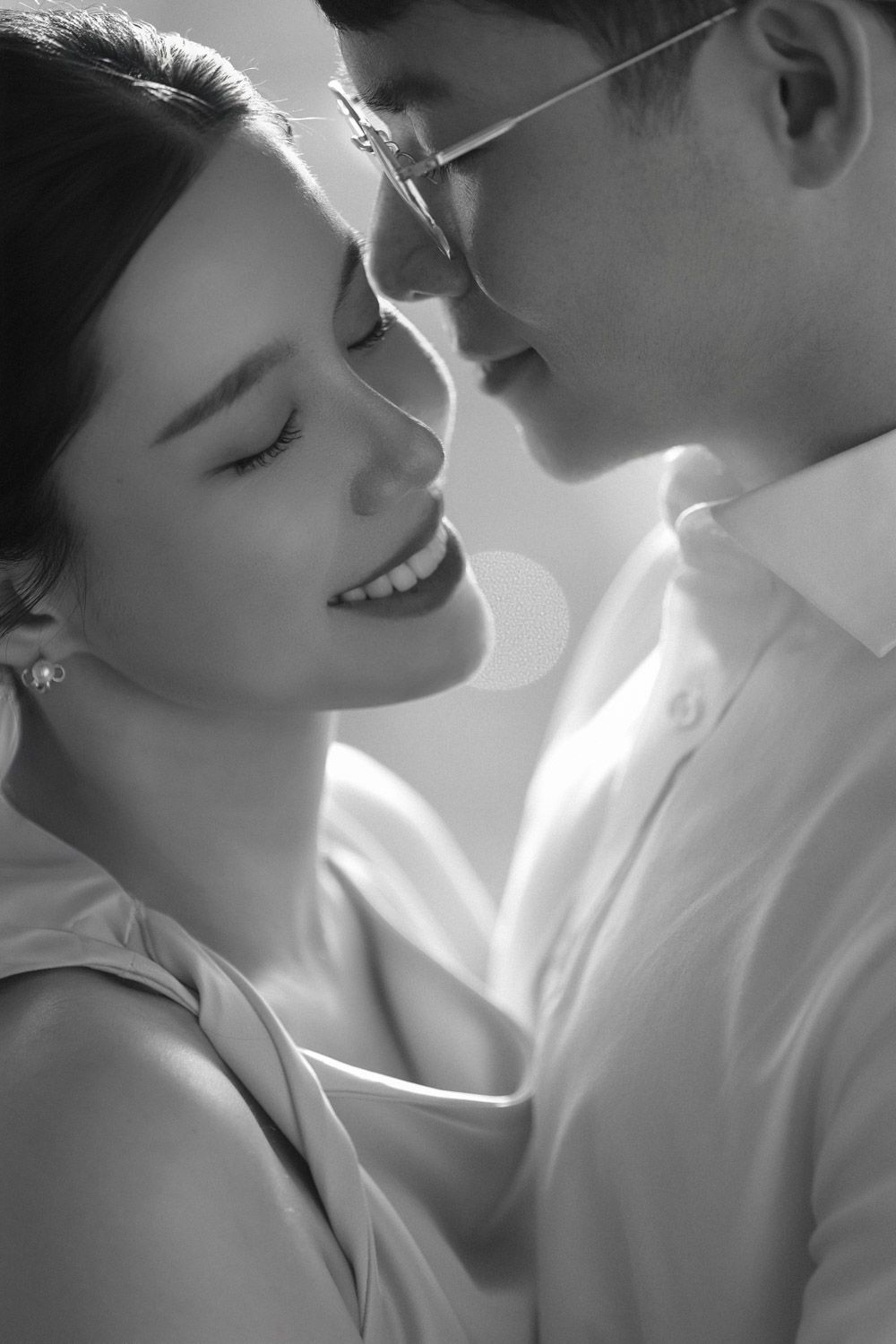 A tender black and white close-up of a couple in a loving forehead-to-forehead moment during their timeless New York engagement session.