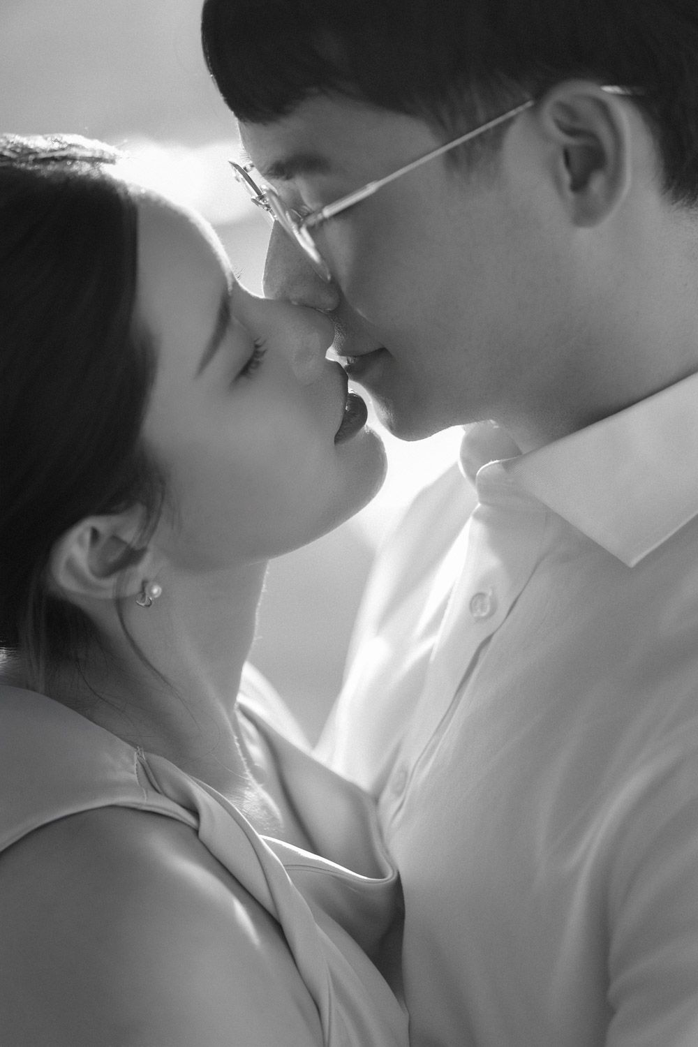 A tender black and white close-up of a couple sharing an intimate almost-kiss moment during their timeless New York engagement session.