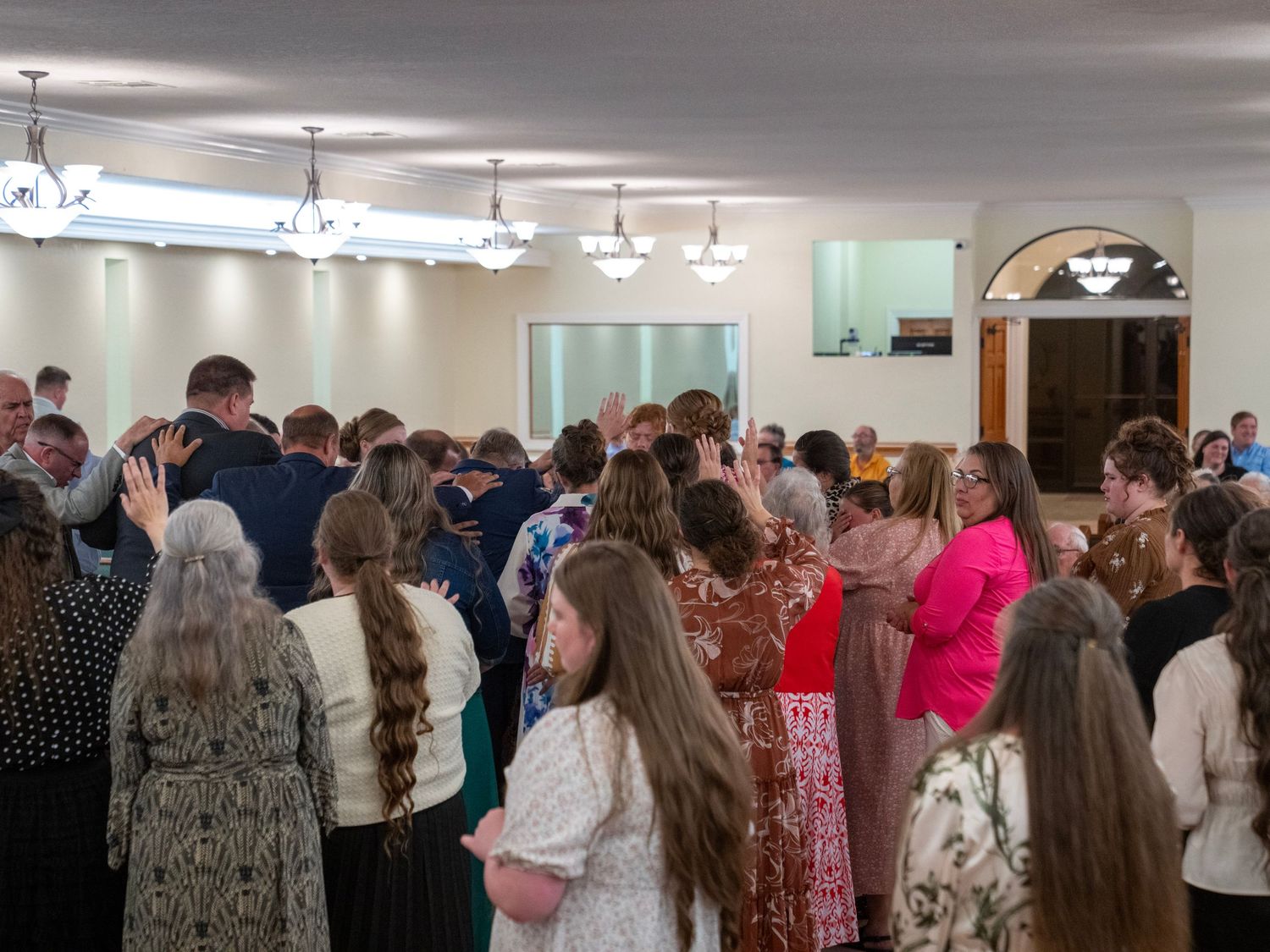 Large congregation standing and worshipping together inside a church sanctuary.