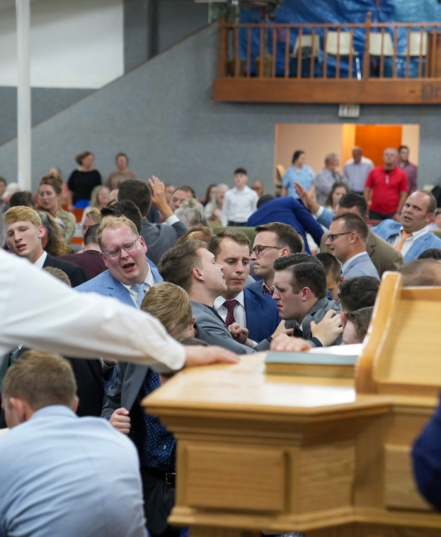 Large crowd of people gathered in prayer at a church service.
