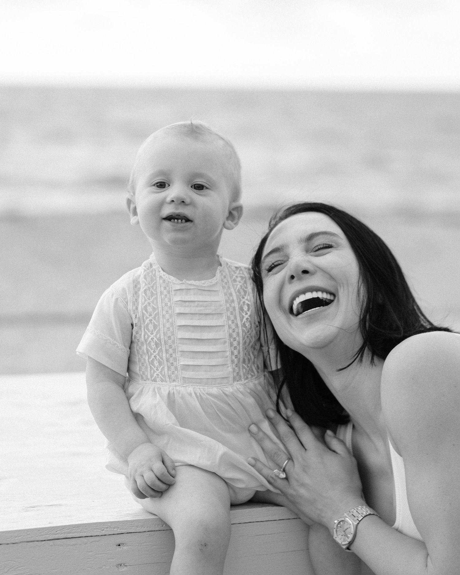 A parent and baby share joyful moments together in black and white photos showing affectionate interaction.