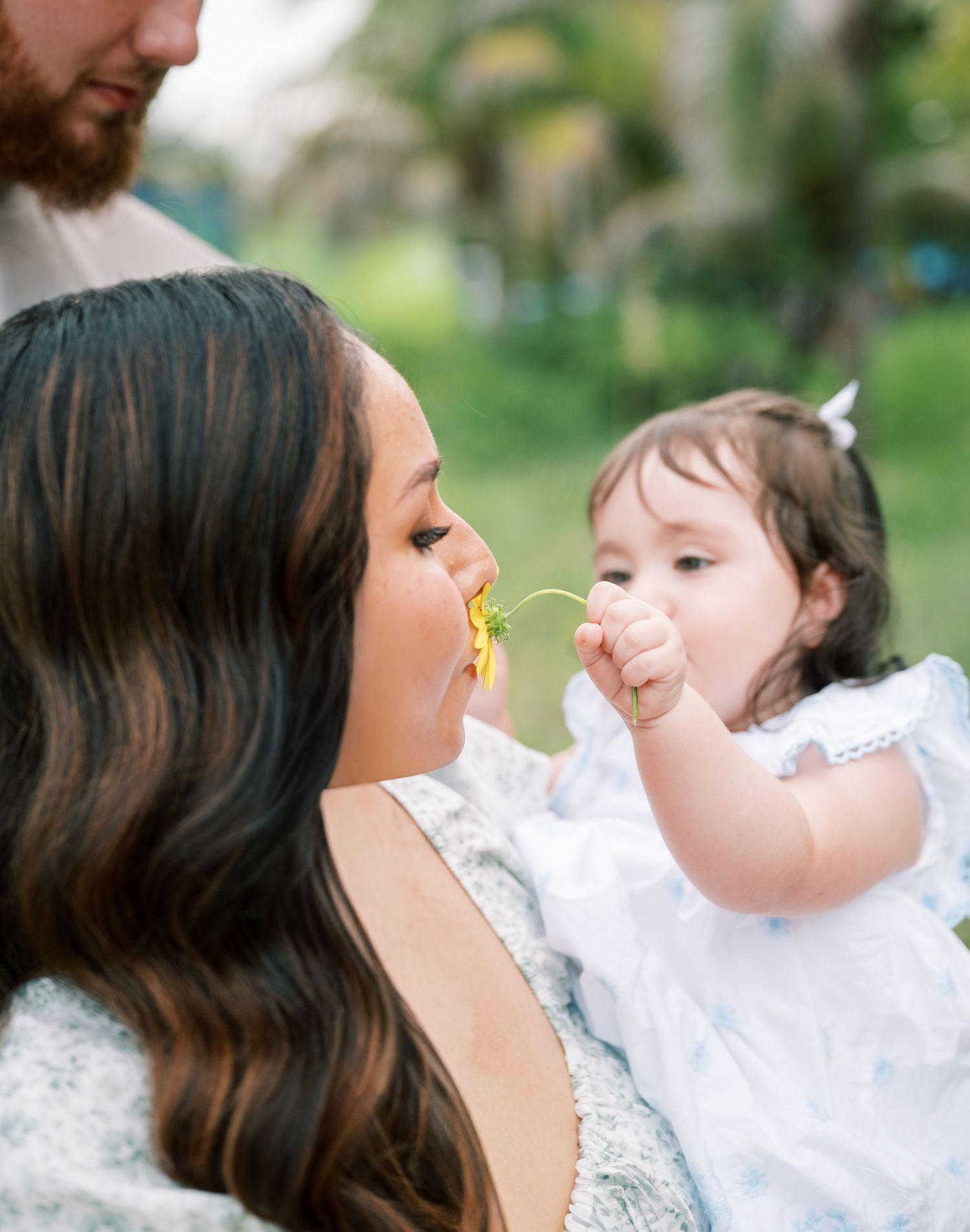 Candid moments of parent and child sharing joyful interactions in a garden setting.