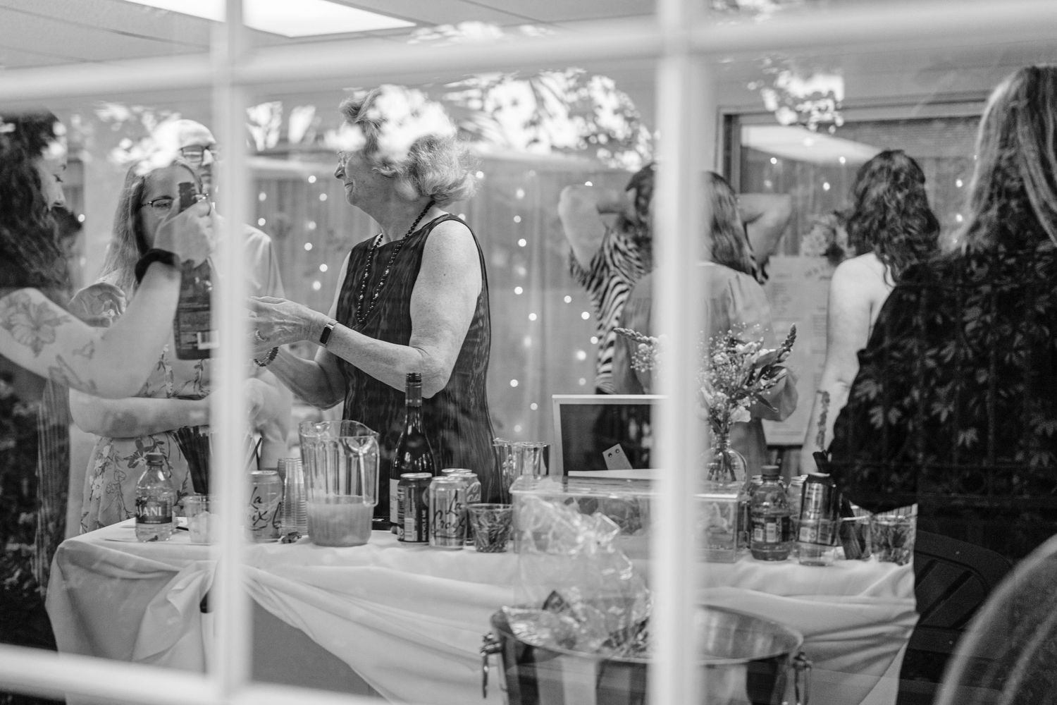 A black and white photo of an elegant wedding reception setup with tables, chairs, and hanging crystal decorations.
