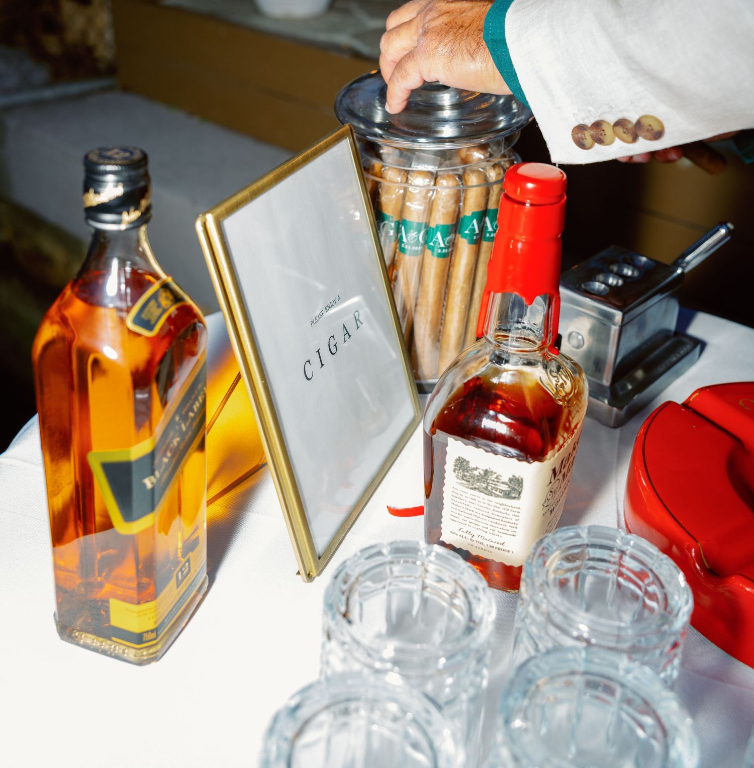 Liquor bottles and glasses arranged on a table with cigar accessories.