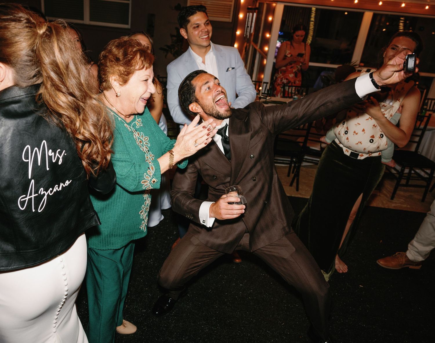 People dancing and celebrating at a lively indoor party with green attire.